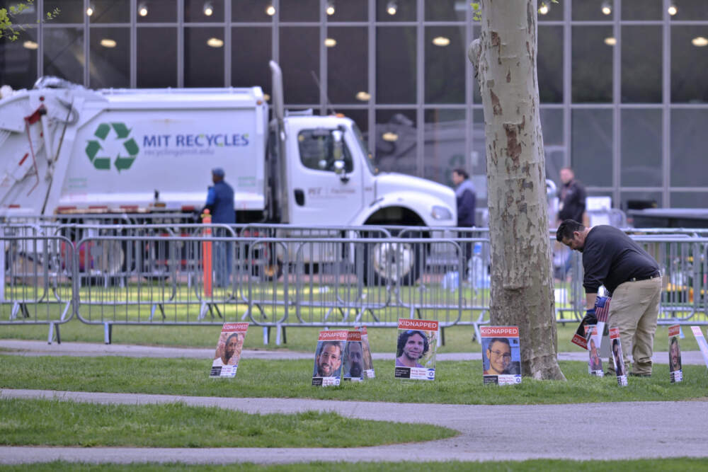 A man removes posters of Israeli hostages from a pro-Israeli display, which were the last items to be removed from the area after police raided and dismantled the pro-Palestinian encampment at MIT, which police raided before dawn Friday, May 10, 2024, in Cambridge, Mass. (Josh Reynolds/AP)
