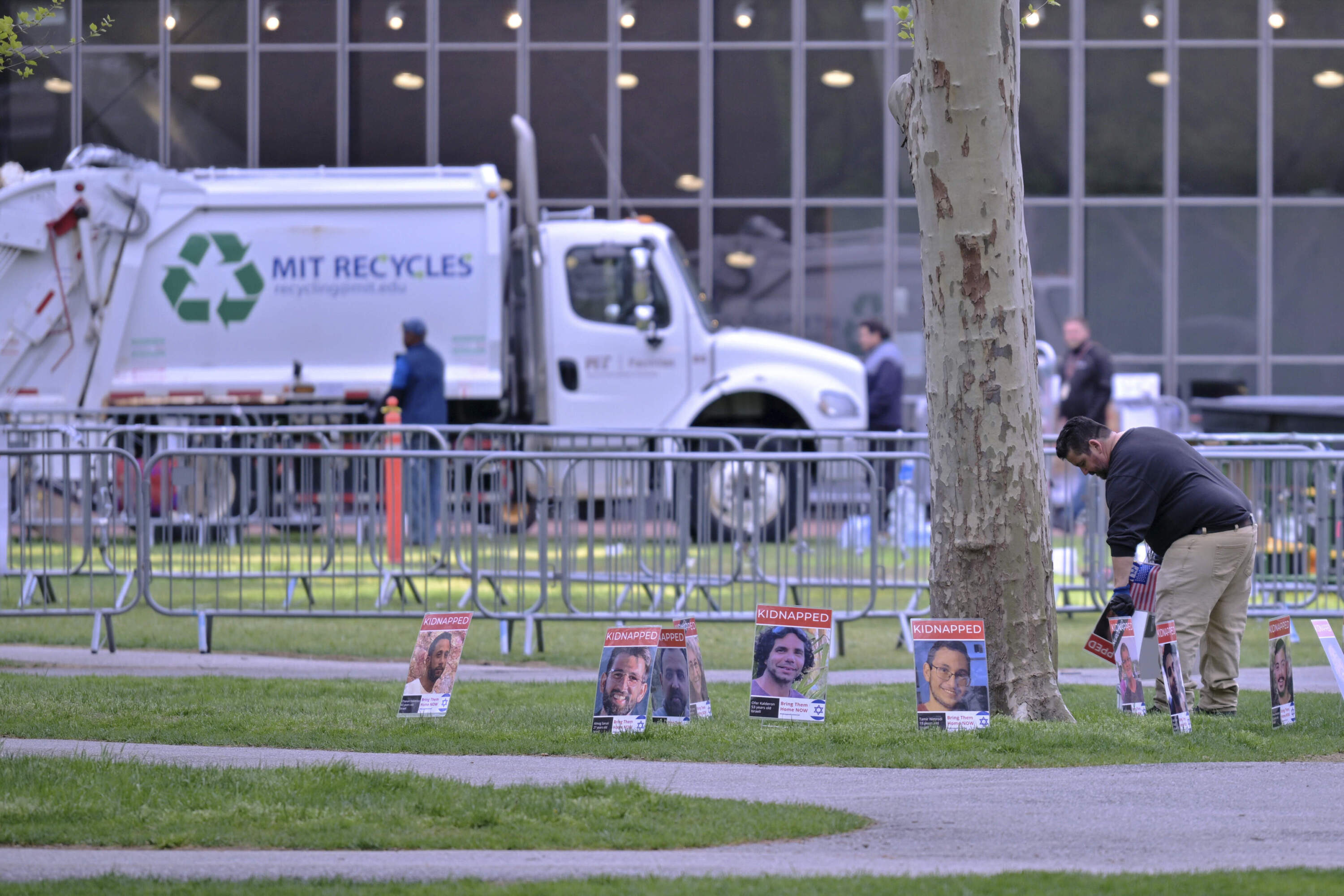 A man removes posters of Israeli hostages from a pro-Israeli display, which were the last items to be removed from the area after police raided and dismantled the pro-Palestinian encampment at MIT, which police raided before dawn Friday, May 10, 2024, in Cambridge, Mass. (Josh Reynolds/AP)