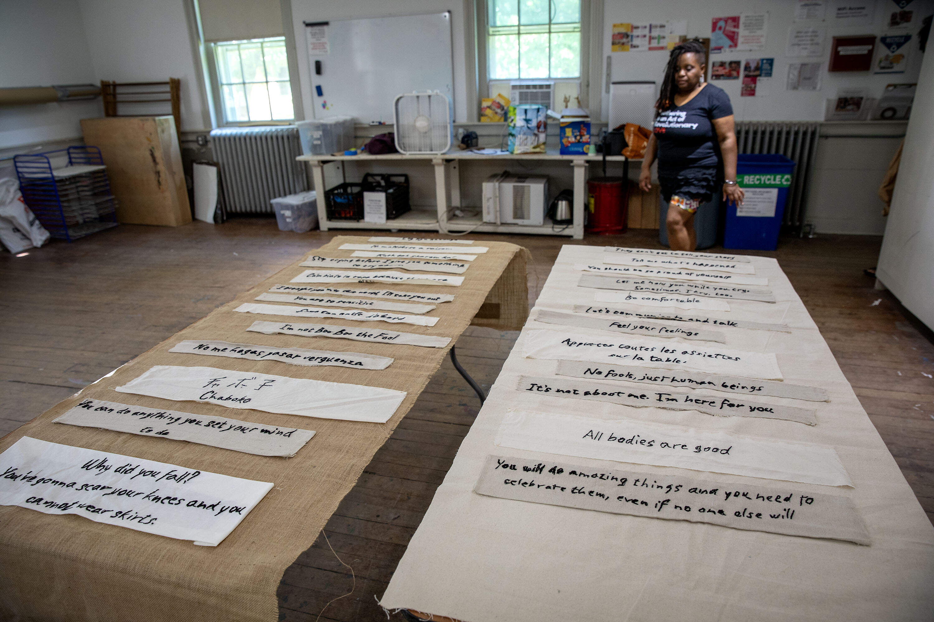 Artist Tanya Nixon-Silberg's "Mother Tongue" shows phrases heard in childhood on a burlap background, and phrases heard today on a muslin background. (Robin Lubbock/WBUR)