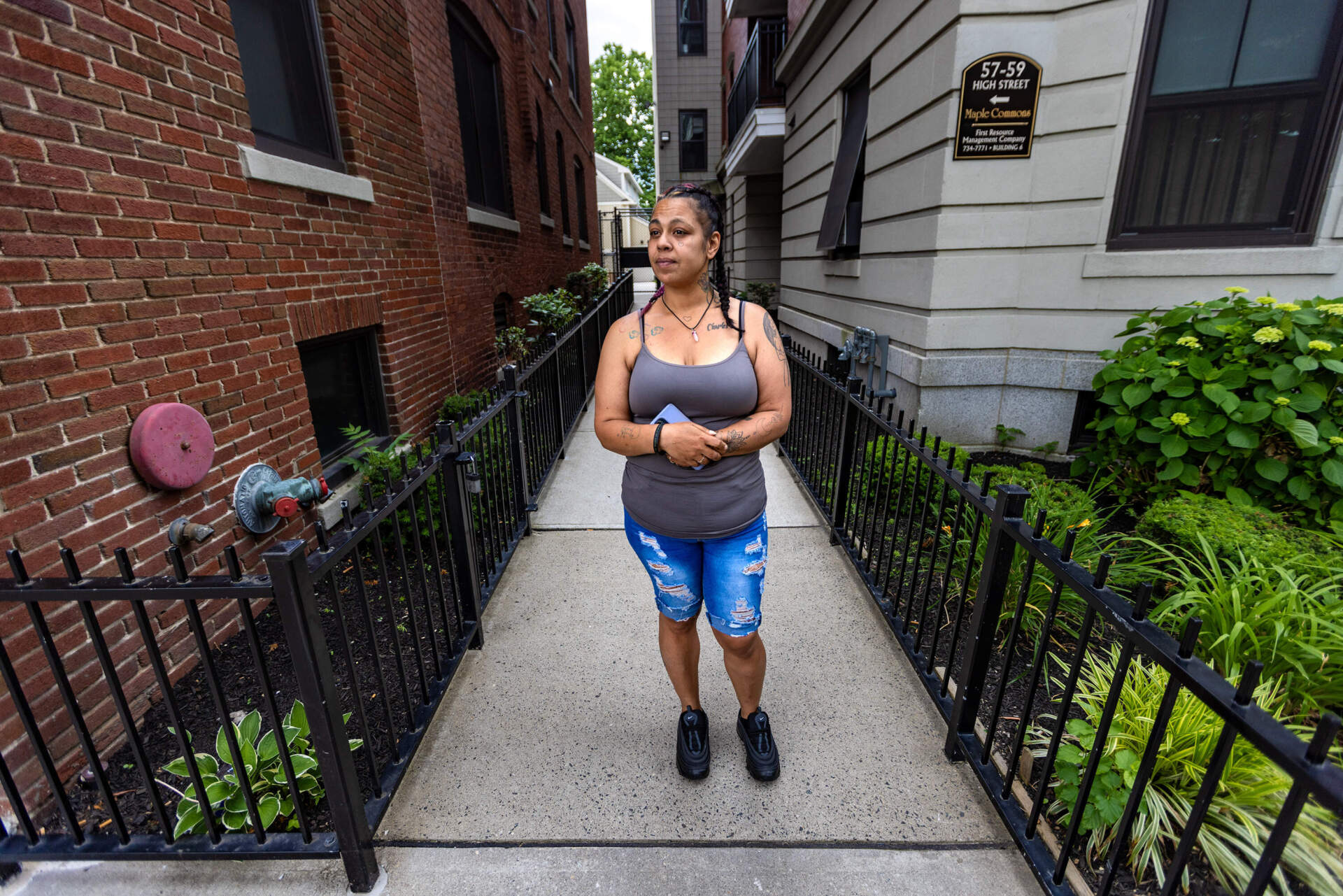 Celinda Cloud looks towards the parking lot across the street from her apartment building, where she rescued a person from overdosing using naloxone from the box on High Street in Springfield. (Jesse Costa/WBUR)