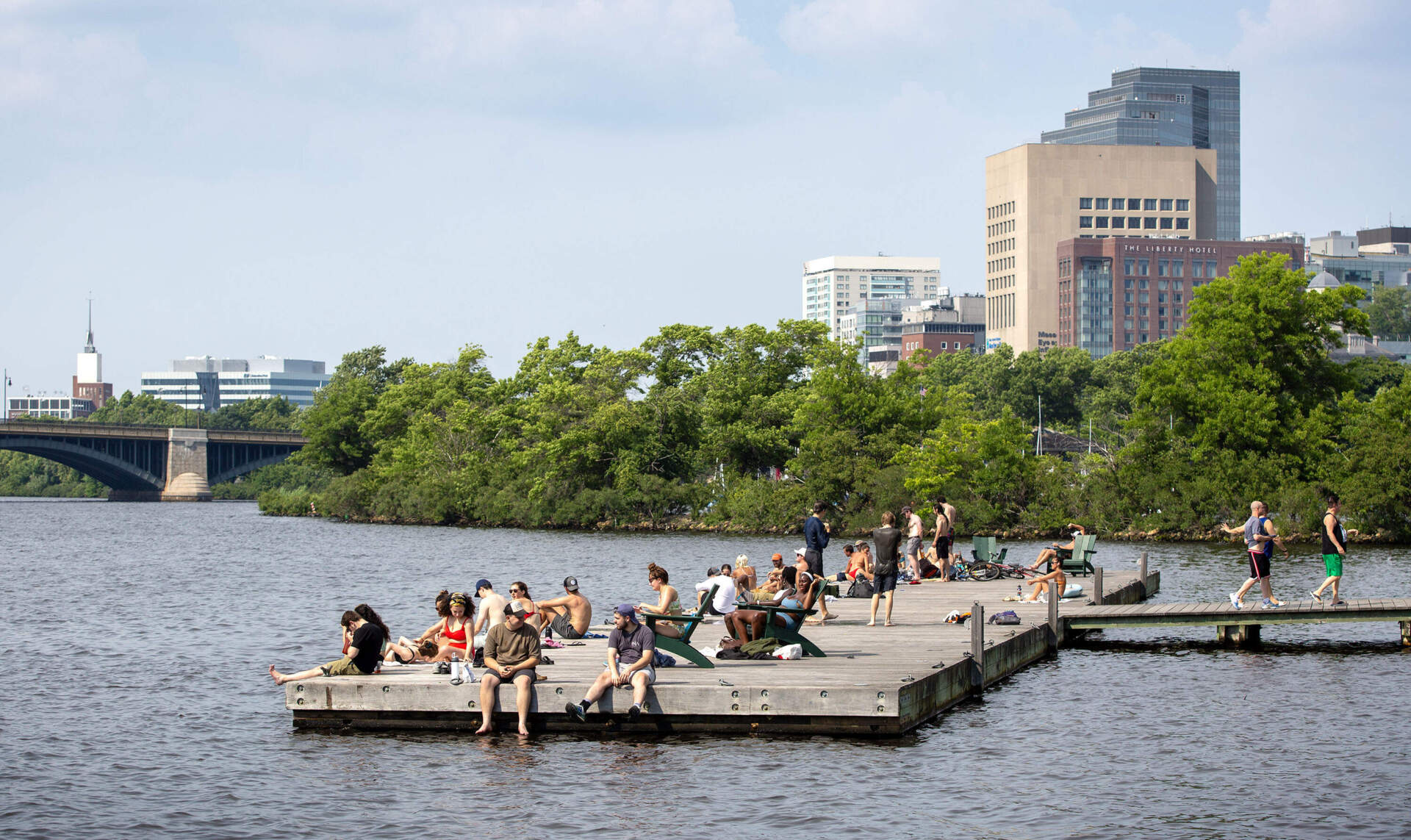 Bostonians seeking relief from the heat gather on a dock by the Charles River Esplanade. (Robin Lubbock/WBUR)