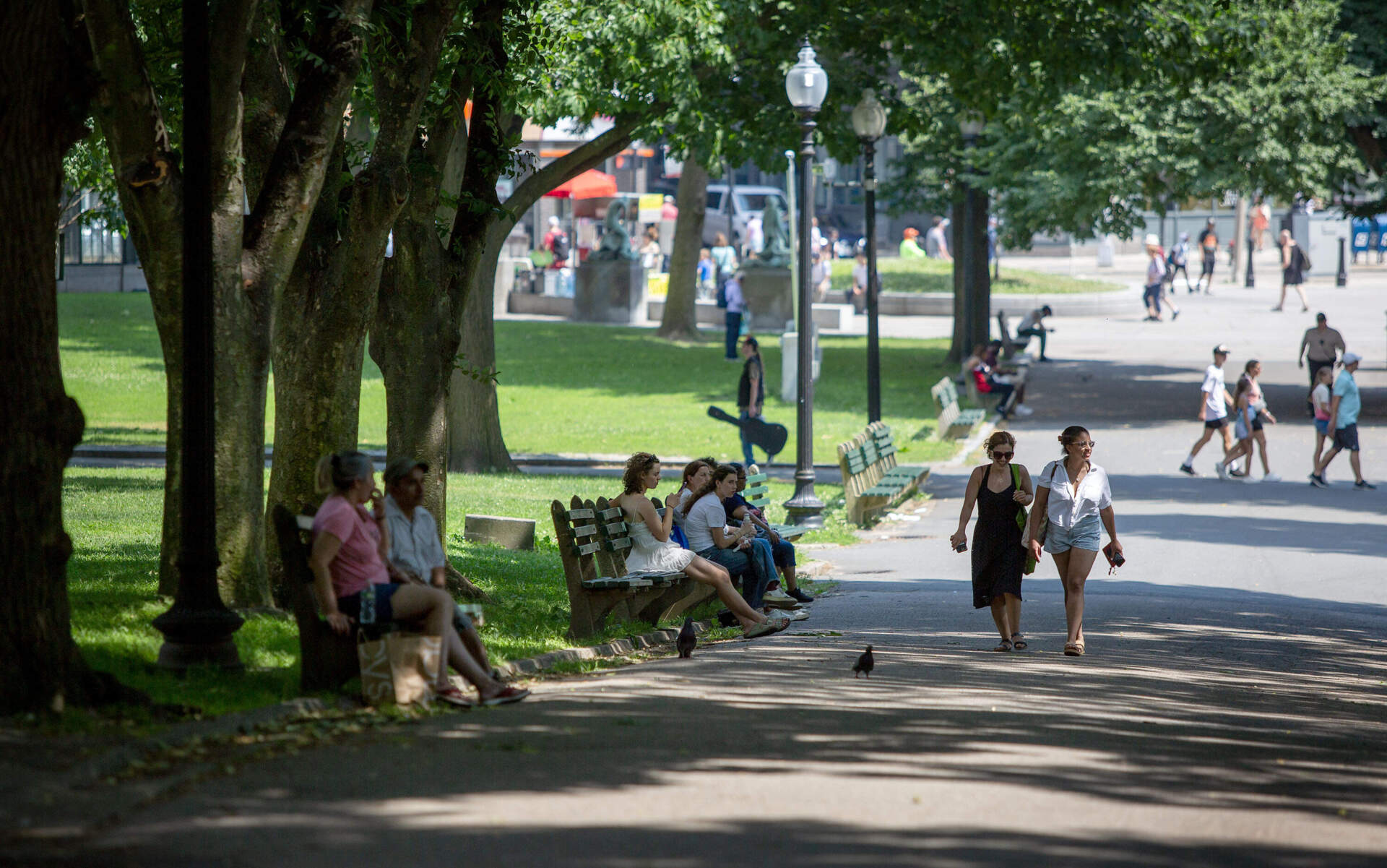 People shelter from the heat on a shady path in Boston Common. (Robin Lubbock/WBUR)