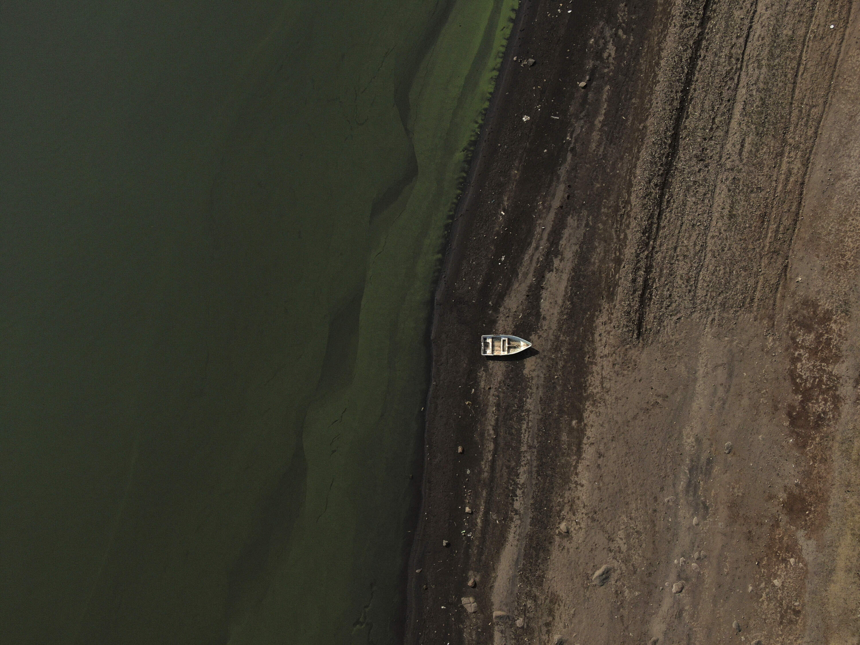 A boat sits idle on the banks of Villa Victoria Dam, the main water supply for Mexico City residents. (Fernando Llano/AP)