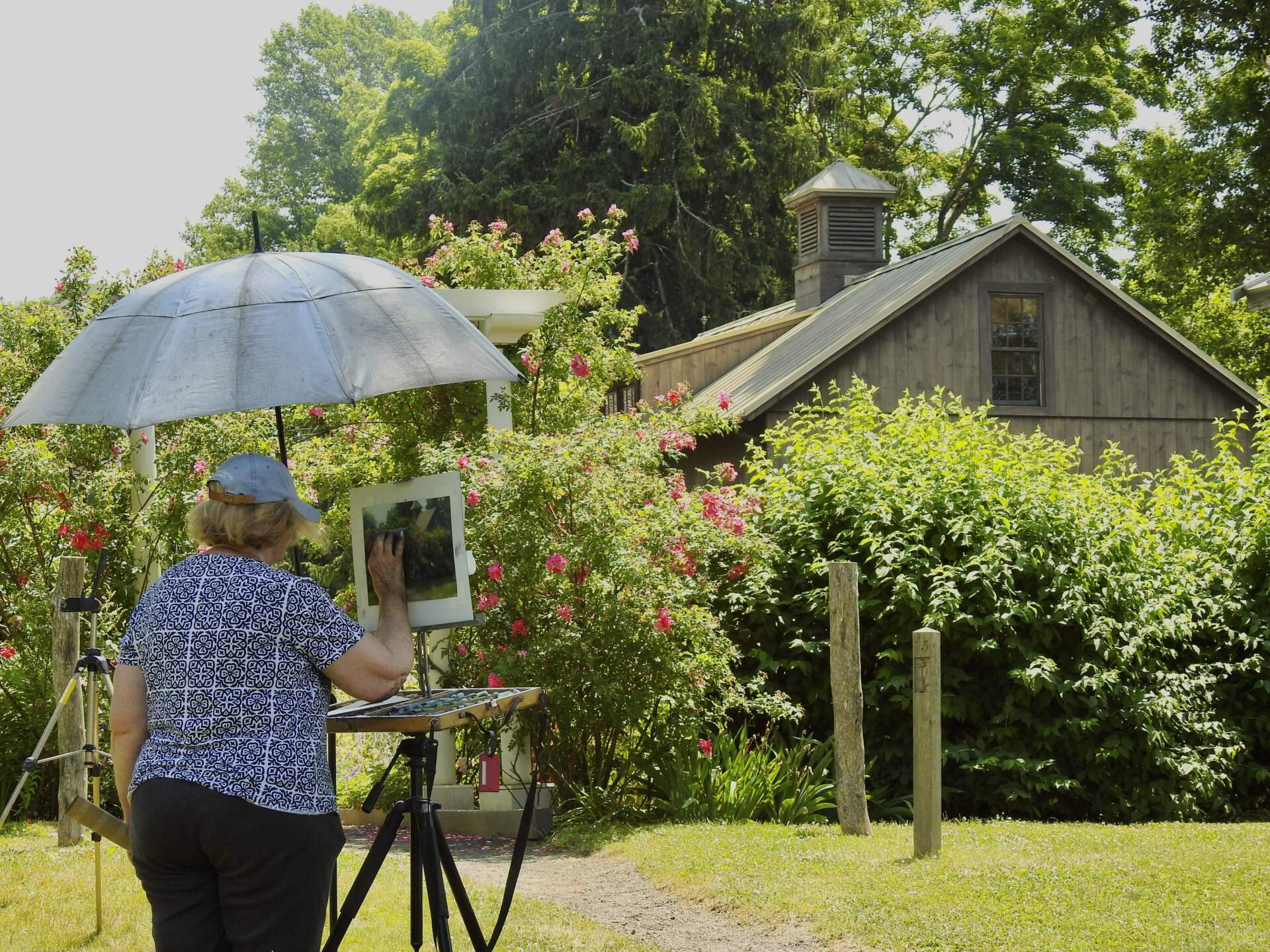 Visitor Beverly Schirmeier recreates the scenery on the campus of the Florence Griswold Museum in Old Lyme, Conn. (Eda Uzunlar/WSHU)
