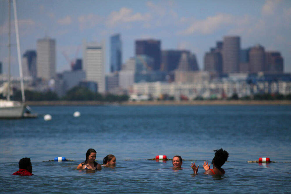 Boston's skyline provides a backdrop for swimmers enjoying the beach on Spectacle Island, Boston on July 29, 2020. (Lane Turner/The Boston Globe via Getty Images)