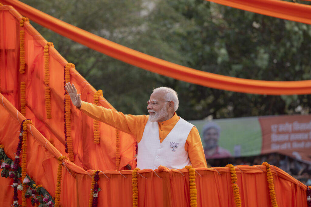 India's Prime Minister, Narendra Modi, greets his supporters during a roadshow on May 13, 2024, in Varanasi, India. (Elke Scholiers/Getty Images)