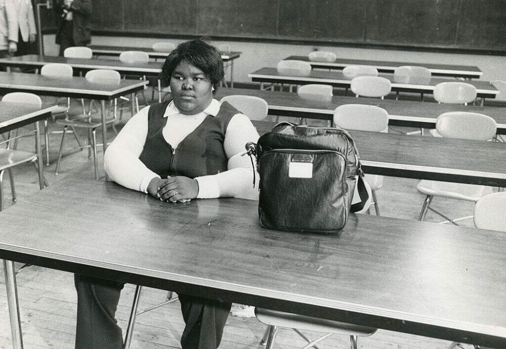 Surrounded by empty seats, Valerie Banks, of Roxbury, sits in a classroom in Boston, Mass. on Sept. 12, 1974. (Dan Sheehan/The Boston Globe via Getty Images)
