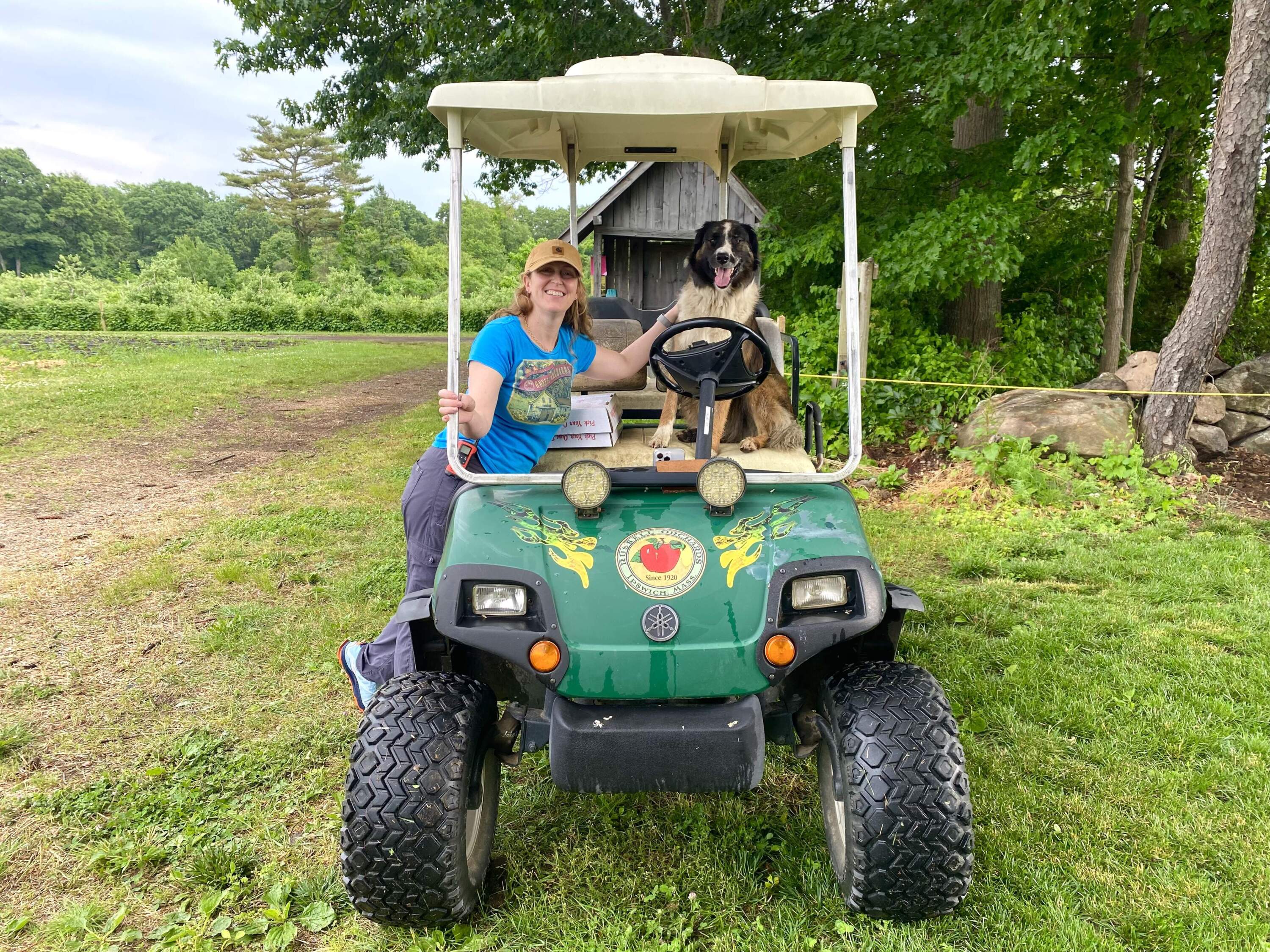 Miranda Russell, co-owner of Russell Orchards with her dog Rhubarb at their fruit farm in Ipswich (Andrea Shea/WBUR)