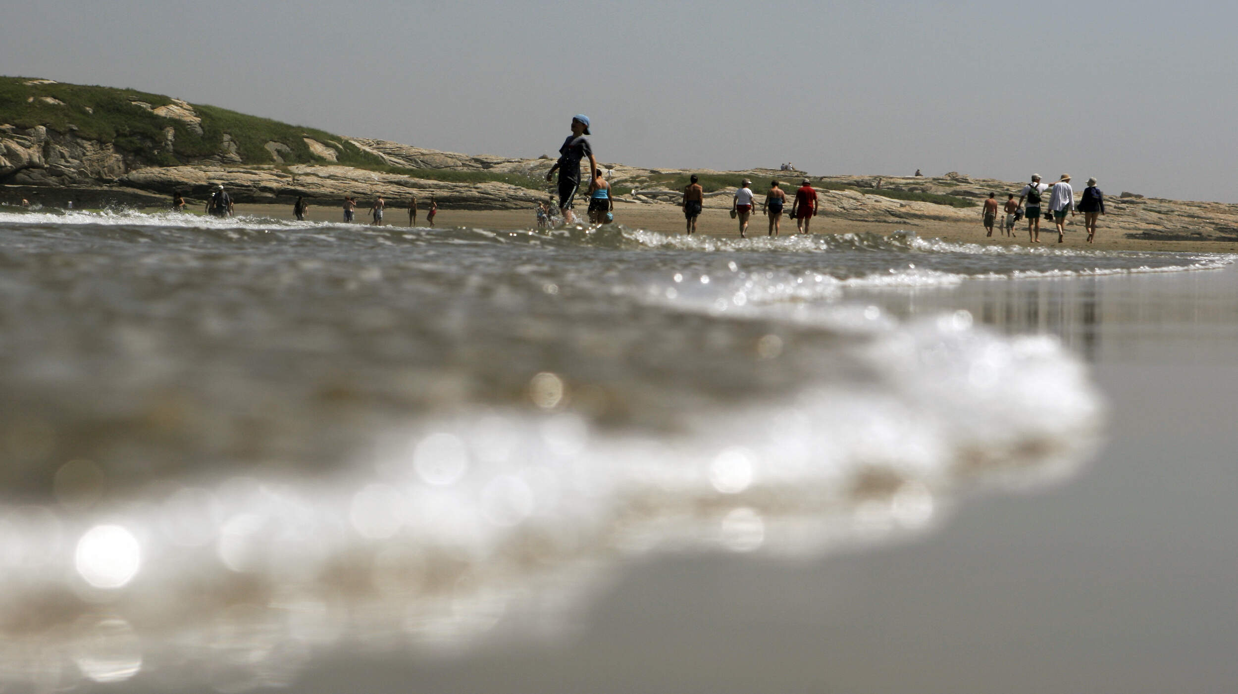 Beachgoers enjoy the walk at low tide at Popham Beach State Park in Phippsburg, Maine in 2007. (Pat Wellenbach/AP)