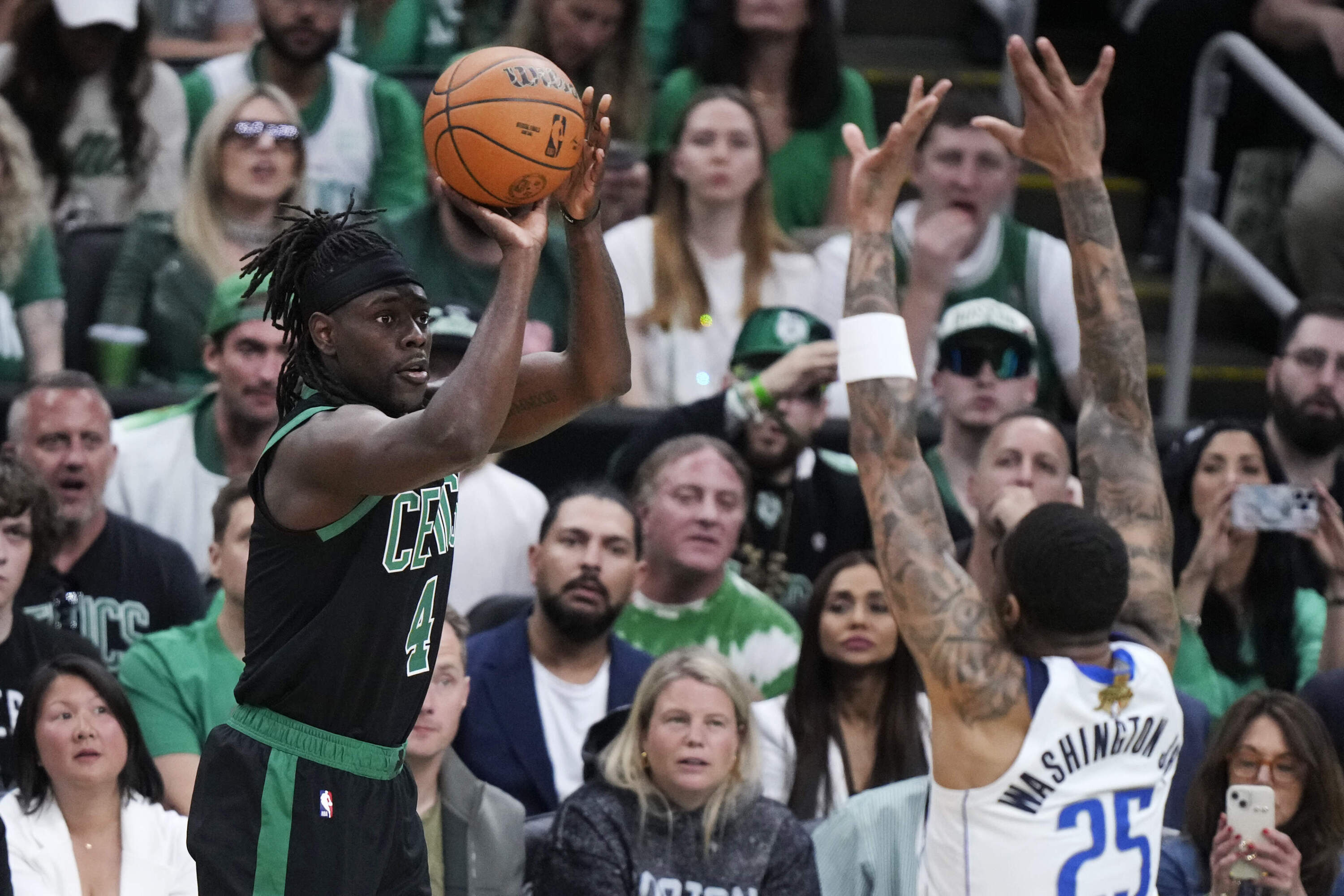 Boston Celtics guard Jrue Holiday takes a shot over Dallas Mavericks forward P.J. Washington (25) during the first half of Game 2 of the NBA Finals basketball series, Sunday, June 9, 2024, in Boston. (Steven Senne/AP)