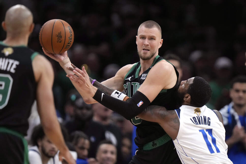 Boston Celtics center Kristaps Porzingis looks to pass while defended by Dallas Mavericks guard Kyrie Irving (11) during the second half of Game 2 of the NBA Finals basketball series, Sunday, June 9, 2024, in Boston. (Steven Senne/AP)