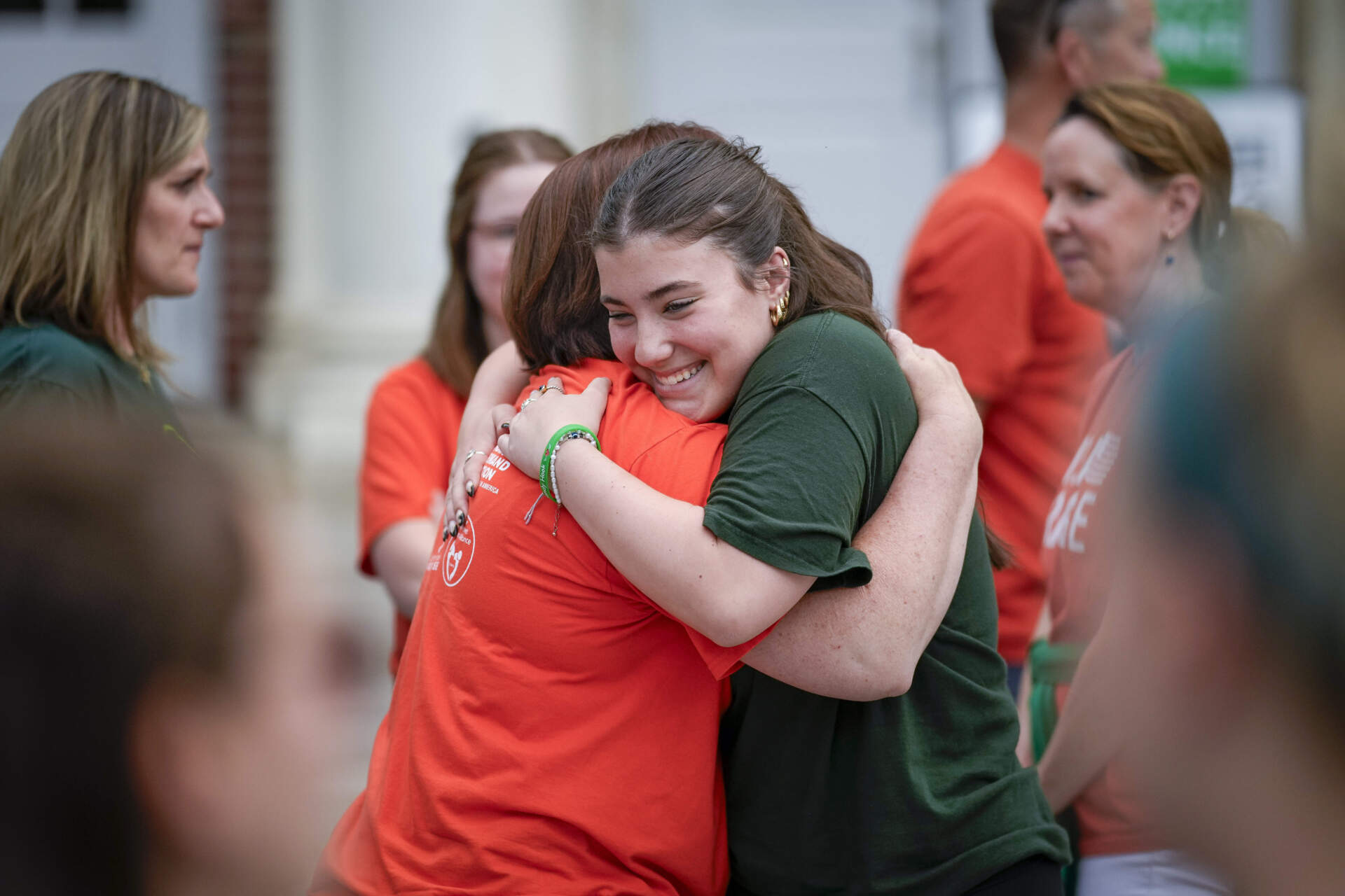 Emma Ehrens, a survivor of the 2012 Sandy Hook Elementary School shooting, hugs a family friend during a rally against gun violence. (Bryan Woolston/AP)