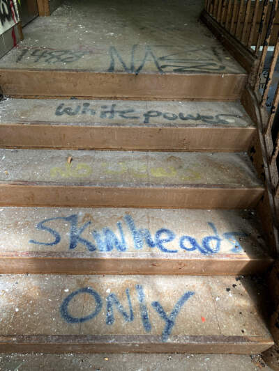 Graffiti found spray-painted onto the steps of a staircase inside the Fernald School in Waltham. (Courtesy Bryan Parcival)
