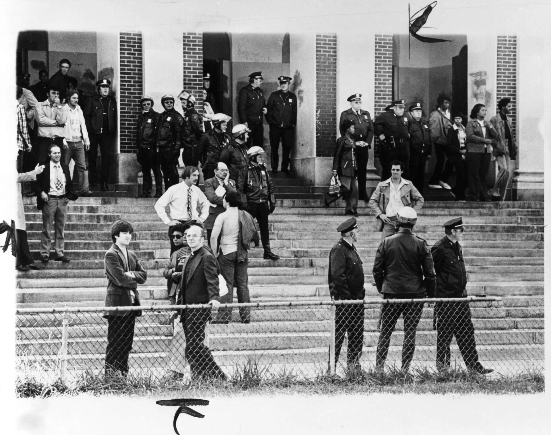 Police outside Hyde Park High School by Stanley Forman from the Herald American, 1974. (James Fraser photograph collection/Northeastern University)