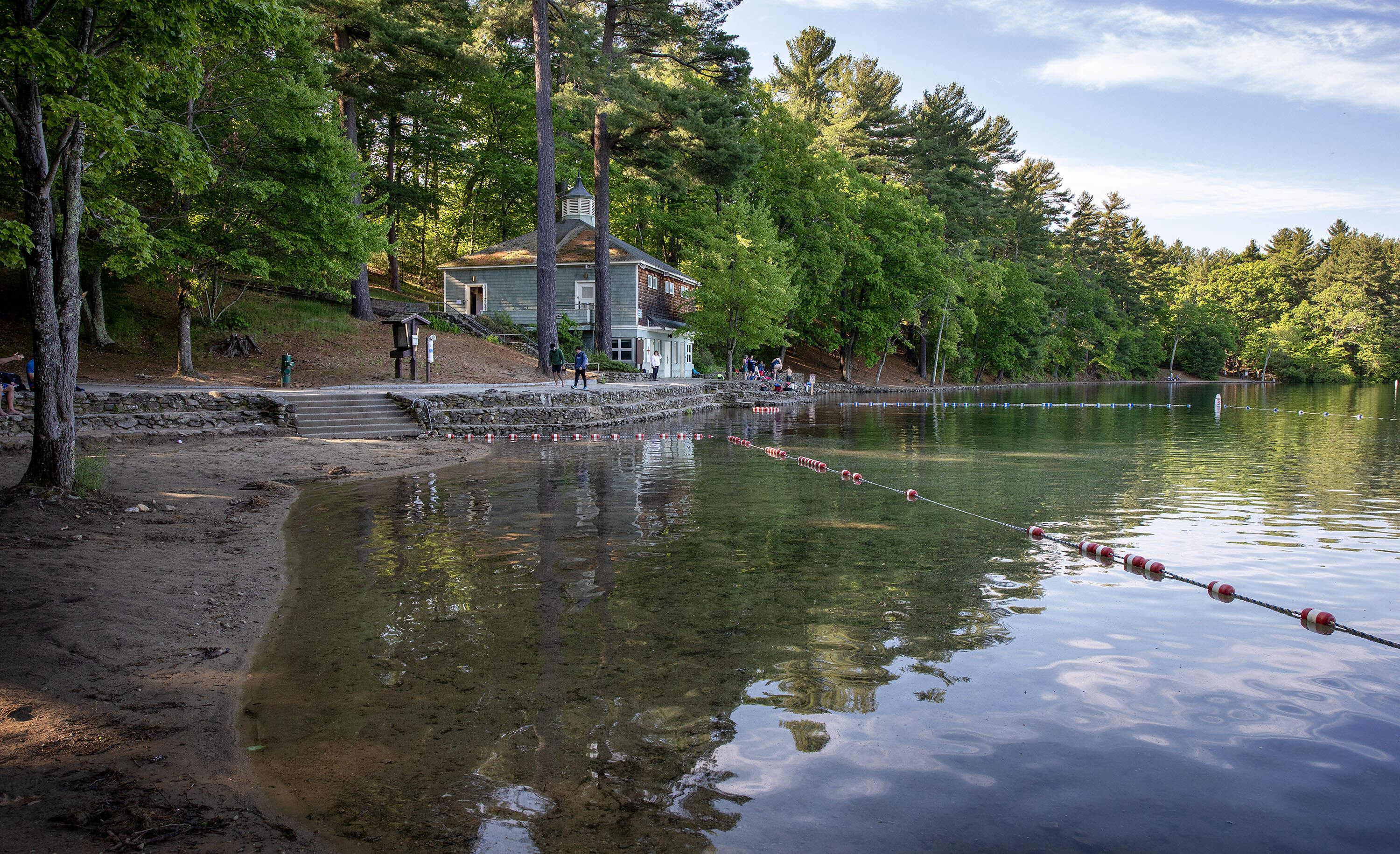 Swimmers stand in front of the bathhouse at Walden Pond. (Robin Lubbock/WBUR)