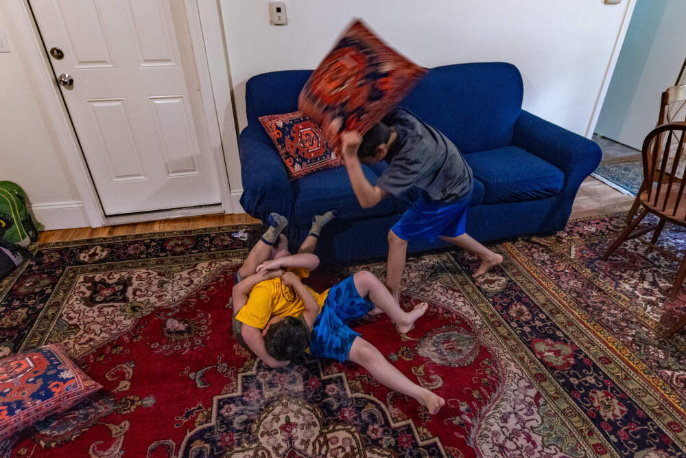 After the kids arrive home from school, the younger boys wrestle and play in the living room. (Jesse Costa/WBUR)