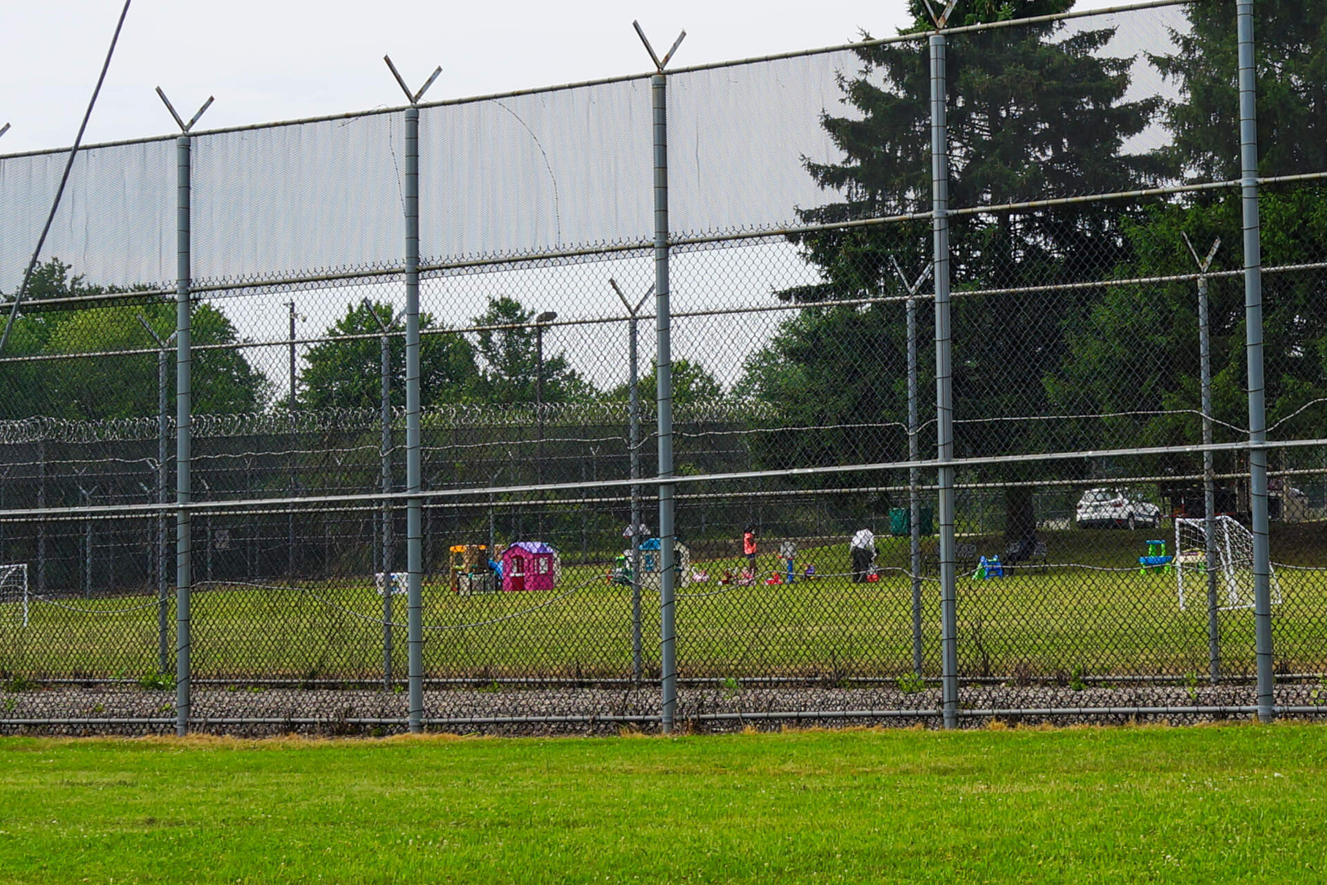 Children’s playhouses and toys are set up the yard of a state prison in Norfolk that closed in 2015. The facility is now being used to house migrants no longer allowed to sleep at Logan Airport. (Simón Rios/WBUR)