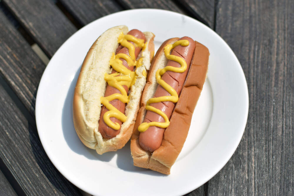 Two hot dogs, side by side. The top-sliced bun is on the right. (Meghan B. Kelly/WBUR)