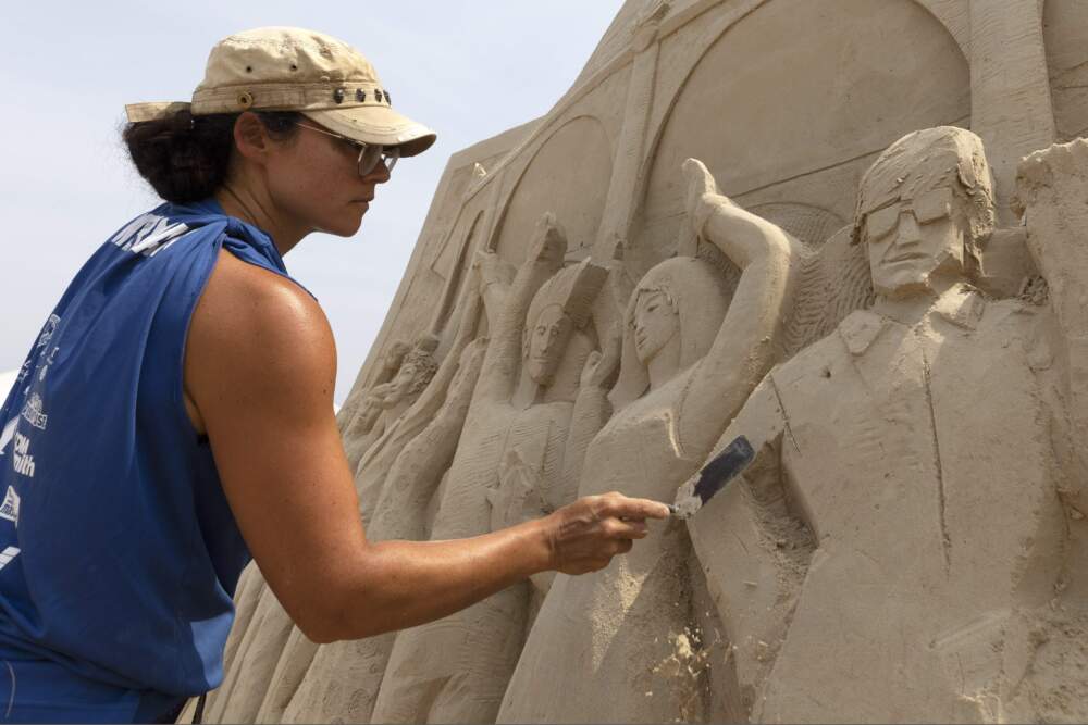 Sue McGrew, of Tacoma, Washington, works on her sand sculpture during the International Sand Sculpting Festival at Revere Beach on Saturday, Aug. 7, 2021, in Revere, Mass. (Michael Dwyer/AP)