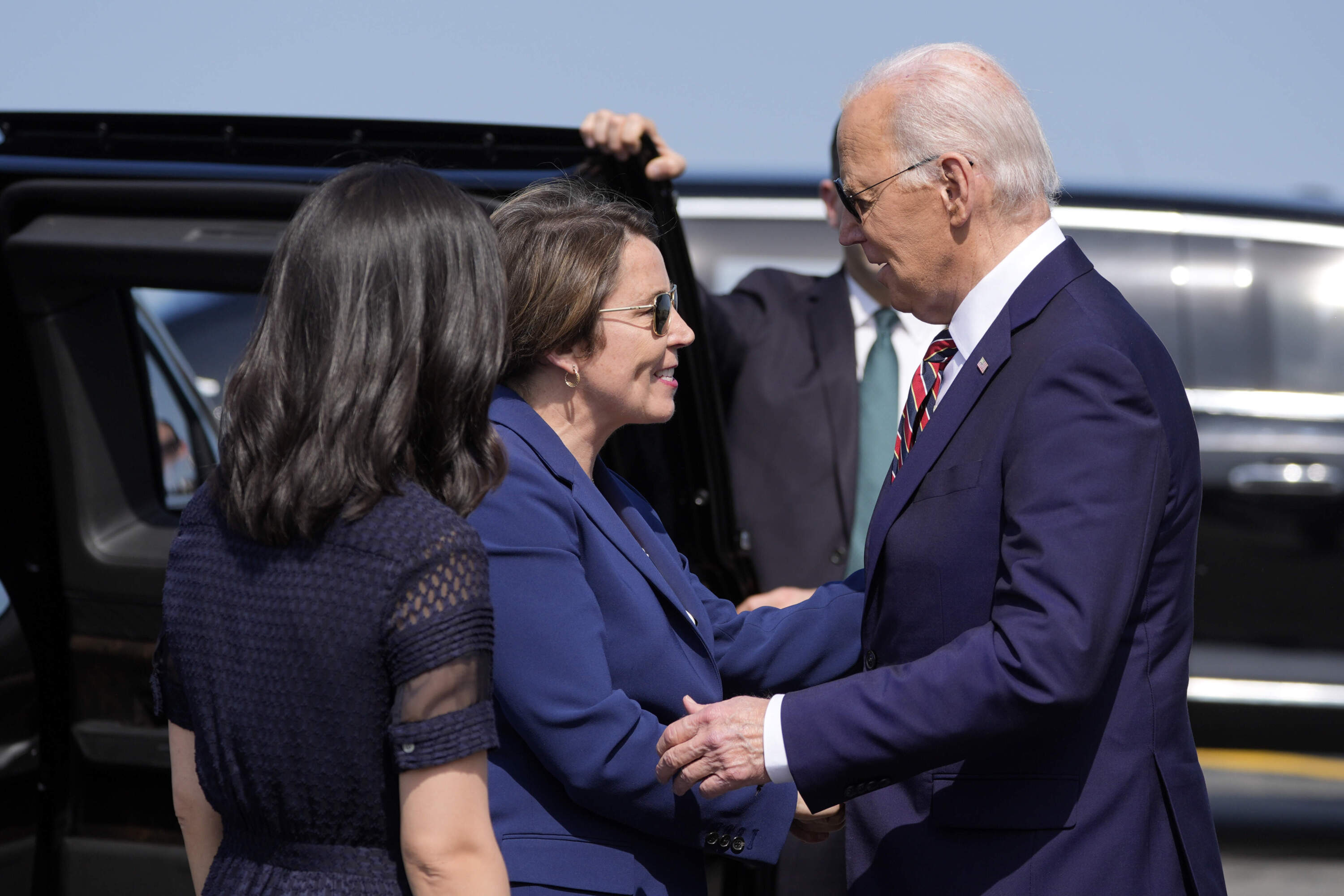 President Joe Biden greets Massachusetts Gov. Maura Healey, center, as he arrives on Air Force One at Boston-Logan International Airport, Tuesday, May 21, 2024. (Alex Brandon/AP)