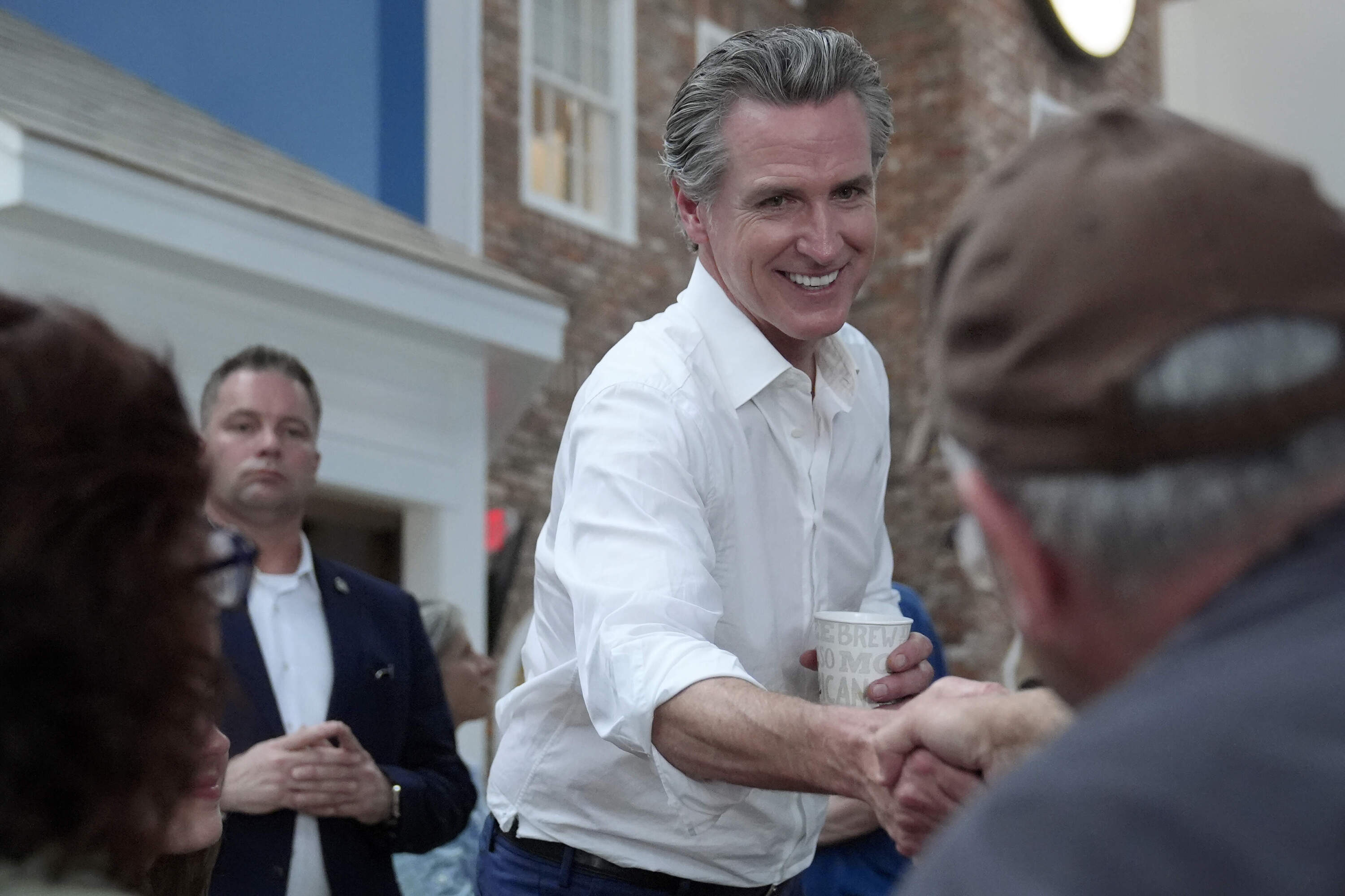 California Gov. Gavin Newsom, center, greets people in Hooksett, N.H. (Steven Senne/AP)