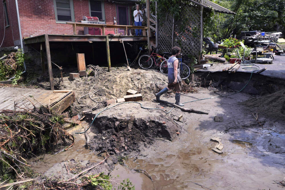 August Thompson walks over the washed out remains of the road in front of his grandfather's home after remnants of Hurricane Beryl caused flooding and destruction in Plainfield, Vt. (Charles Krupa/AP)