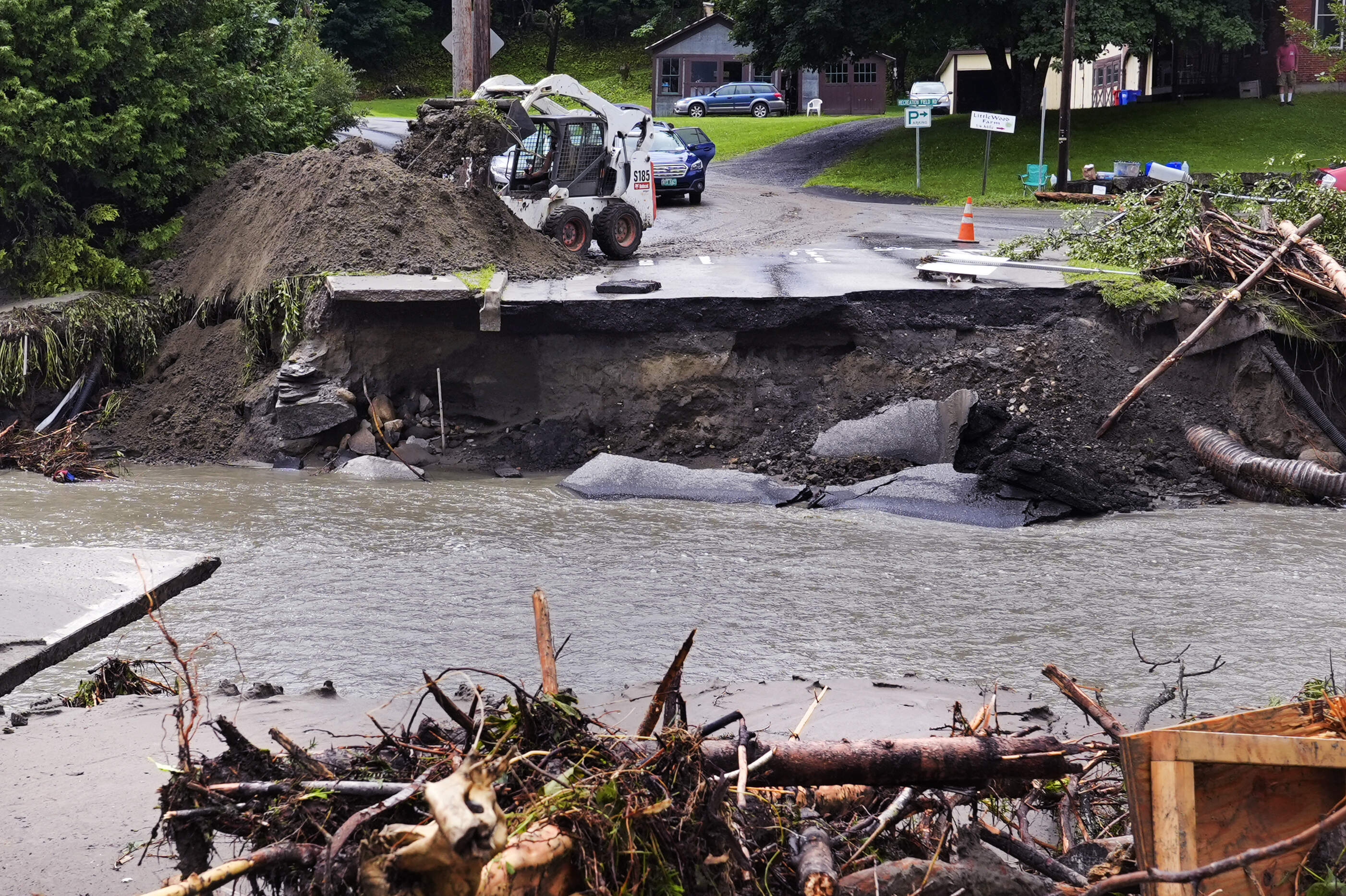 A loader dumps dirt along a washed out portion of Mill Street after remnants of Hurricane Beryl caused flooding and destruction, Friday, July 12, 2024, in Plainfield, Vt. (Charles Krupa/AP)