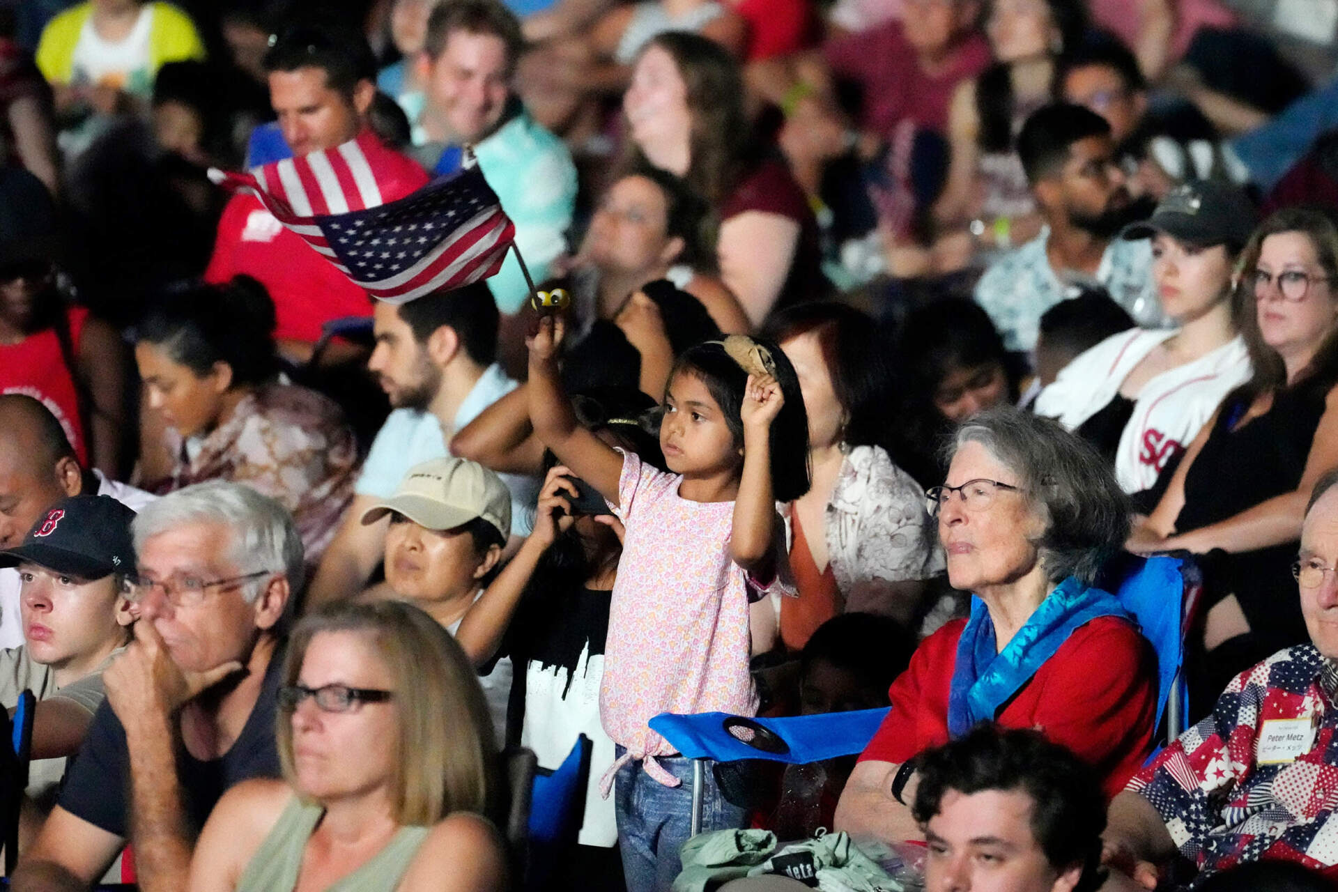 A young girl waves a flag during the Boston Pops Fireworks Spectacular. (Michael Dwyer/AP)