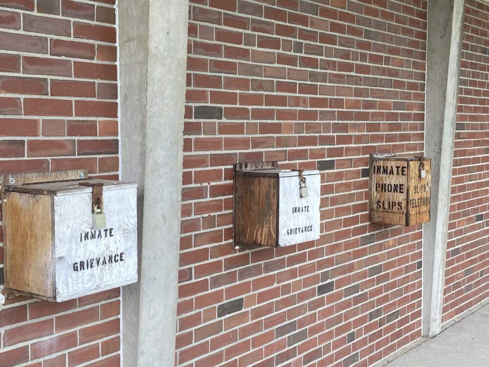 Boxes labeled &quot;inmate grievances&quot; seen in the prison yard at MCI-Concord. (Deborah Becker/WBUR)