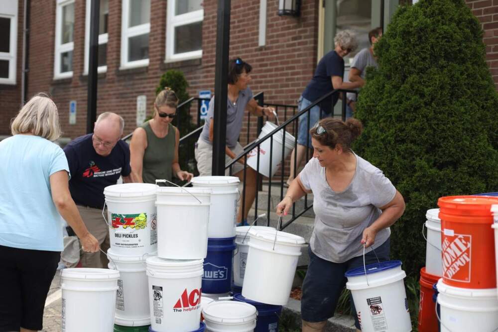 Volunteers carry flood relief supplies into the Hedding United Methodist Church in downtown Barre after the July 2023 floods. (Mike Dougherty/Vermont Public)