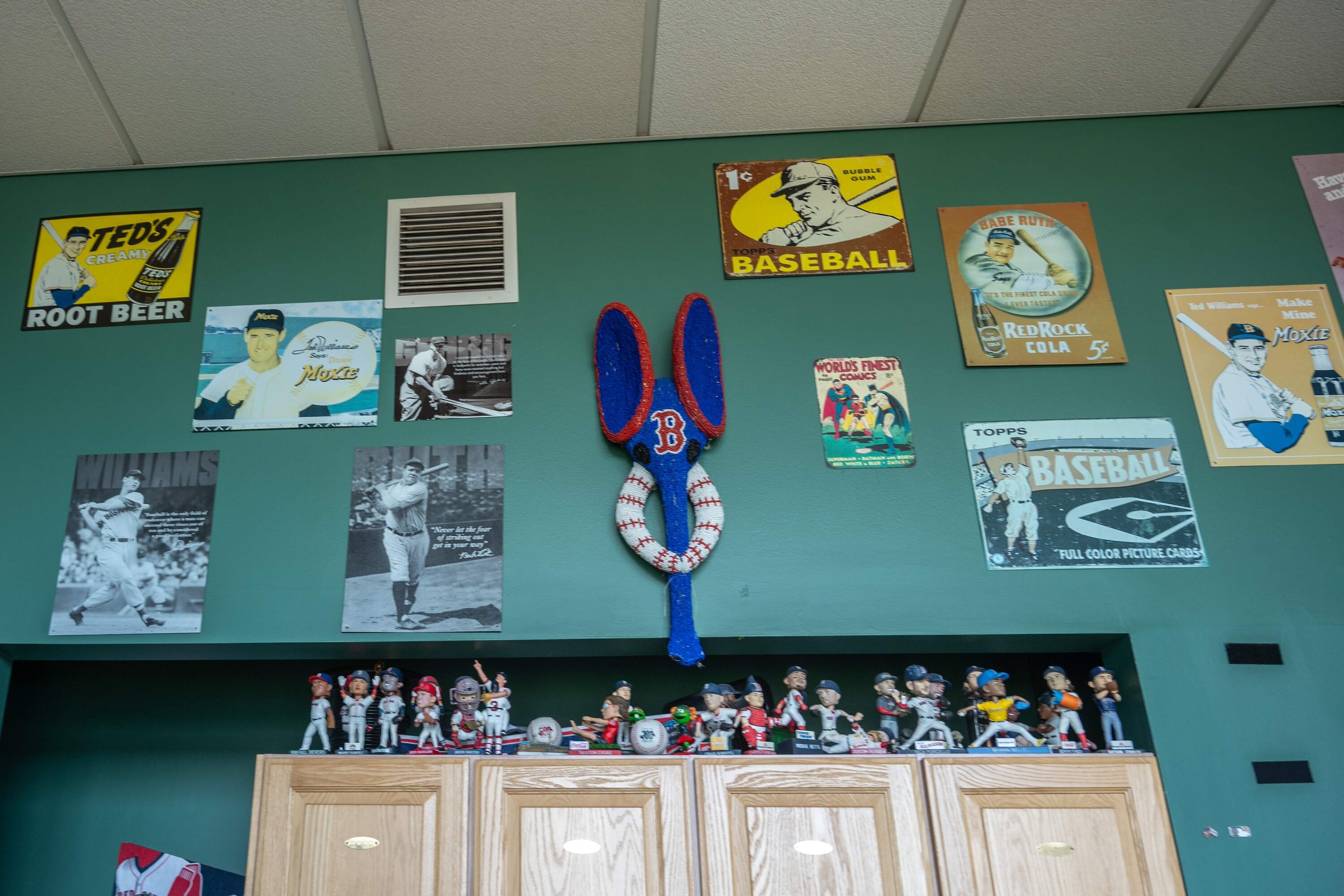 In the Joe Castiglione booth at Fenway Park, the area behind the broadcast team features years' worth of bobbleheads and vintage signs. (Sharon Brody/WBUR)