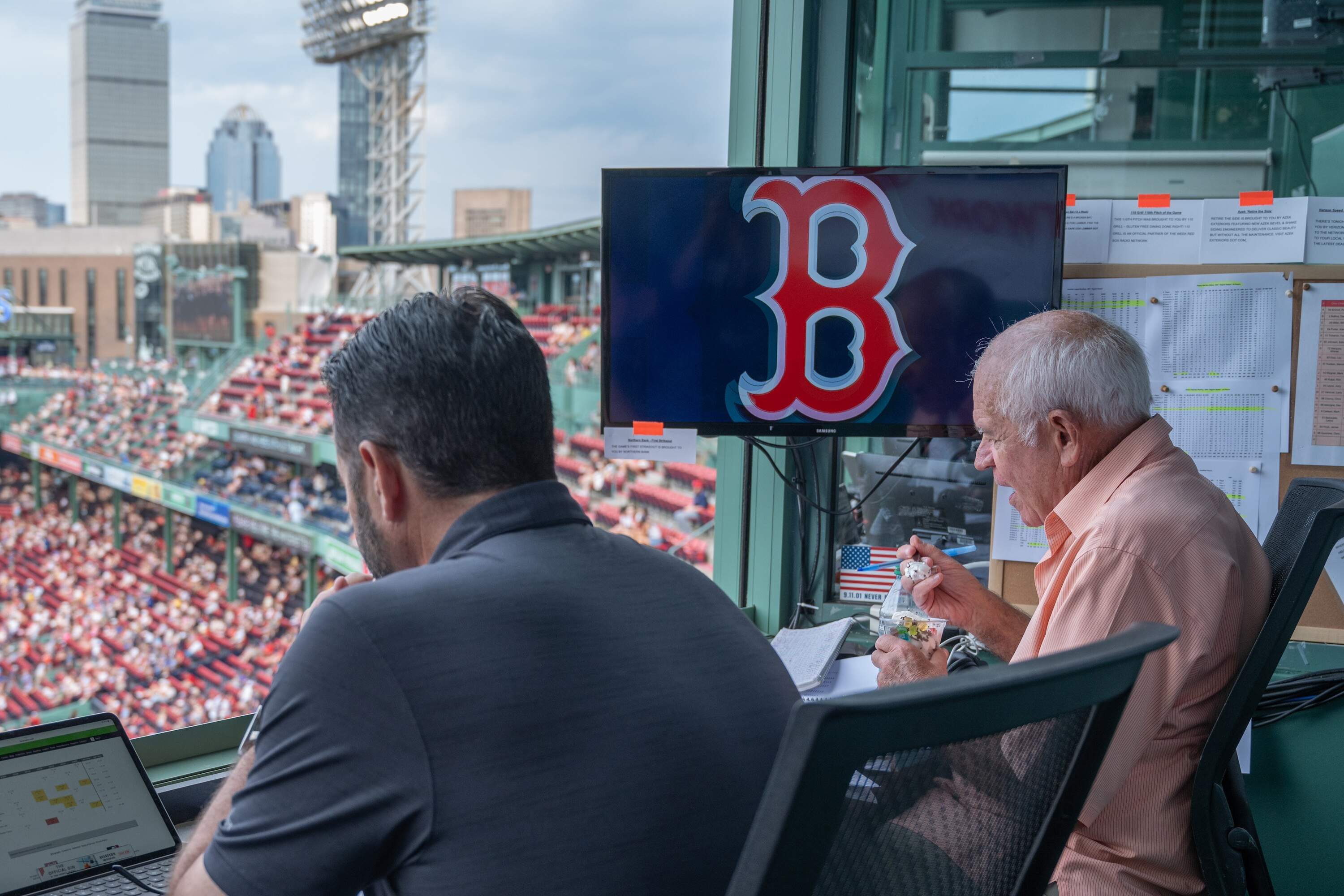 Alongside his colleague Lou Merloni, Joe Castiglione is in his perch at Fenway Park, just before the Red Sox take on the Toronto Blue Jays and just before Castiglione finishes his customary vanilla ice cream with gummy bears from the dining room across the hall from the broadcast booth. (Sharon Brody/WBUR)