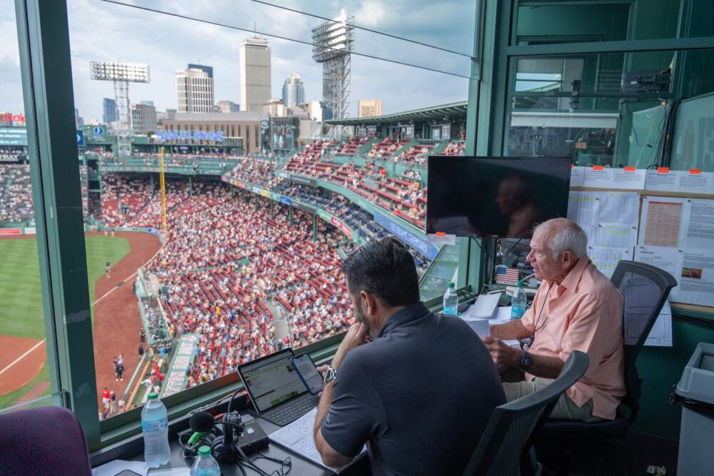 Alongside his colleague Lou Merloni, Joe Castiglione sits in his perch at Fenway Park, just before the Red Sox take on the Toronto Blue Jays. (Sharon Brody/WBUR)