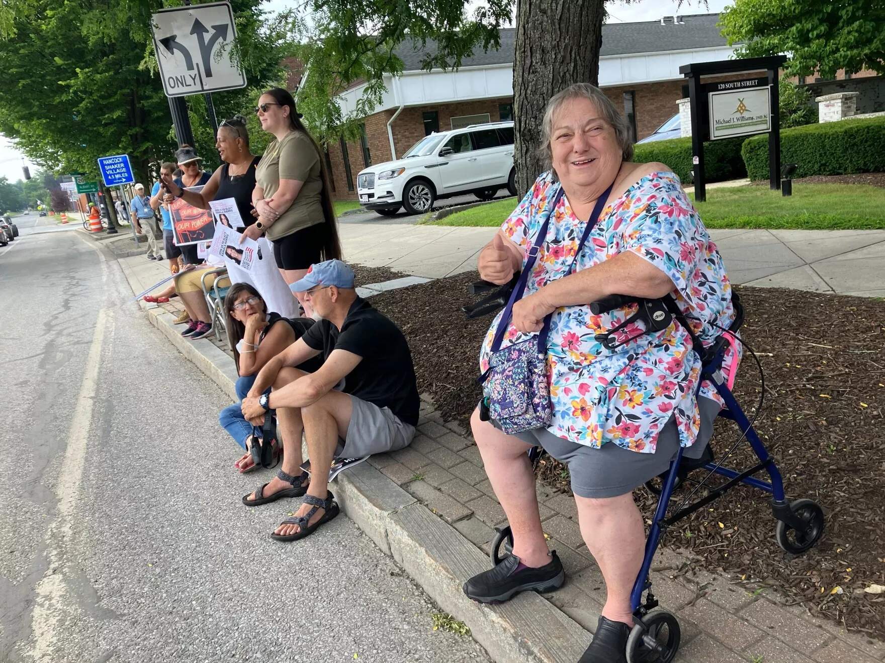 Theresa Daniels, 70, sits across the street from the Colonial Theatre in Pittsfield, Massachusetts, where Vice President Kamala Harris was speaking at a fundraiser on July 27, 2024. (Nancy Eve Cohen/NEPM)