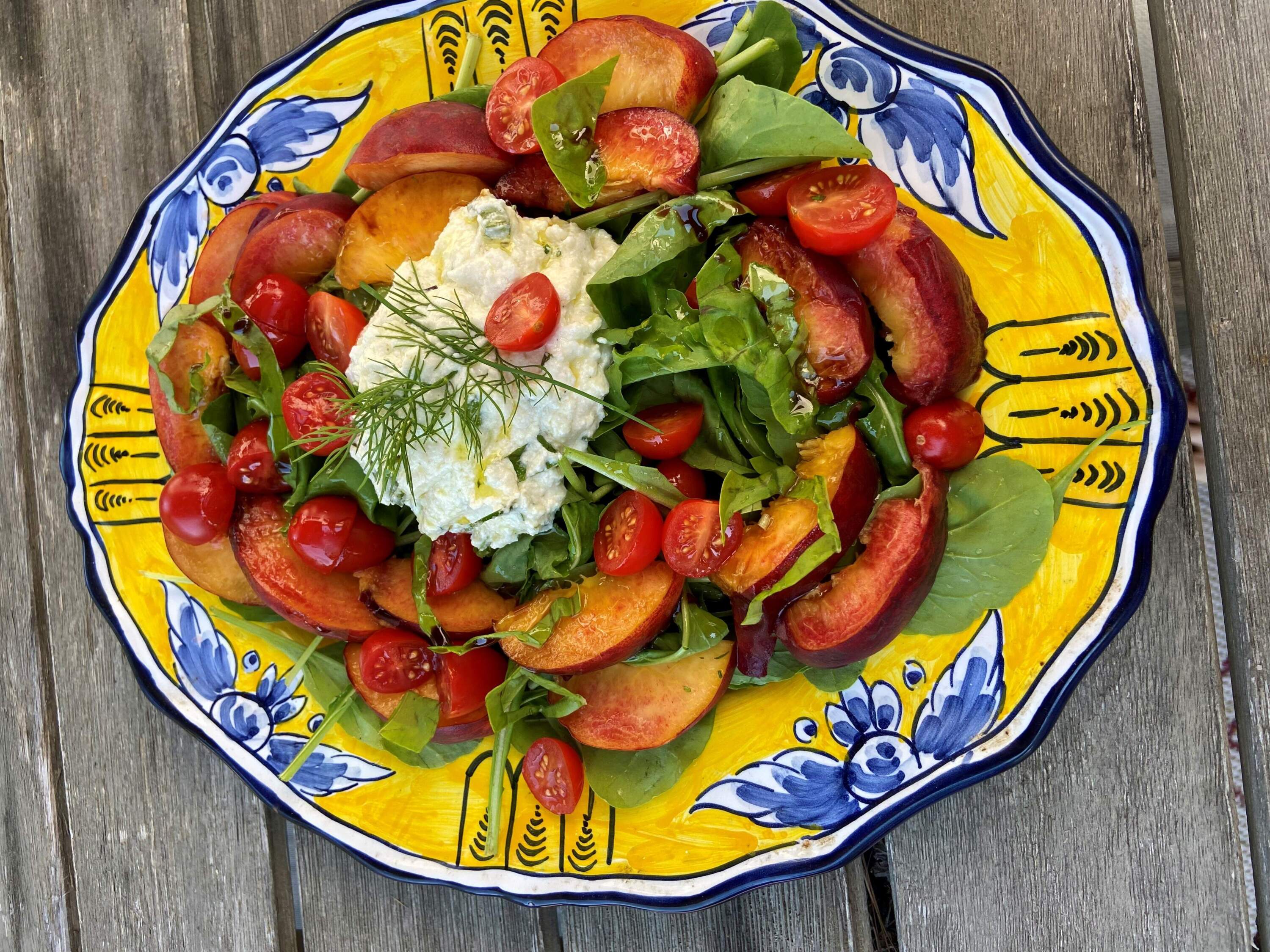 Peach, tomato and ricotta salad on arugula. (Kathy Gunst/Here &amp; Now)