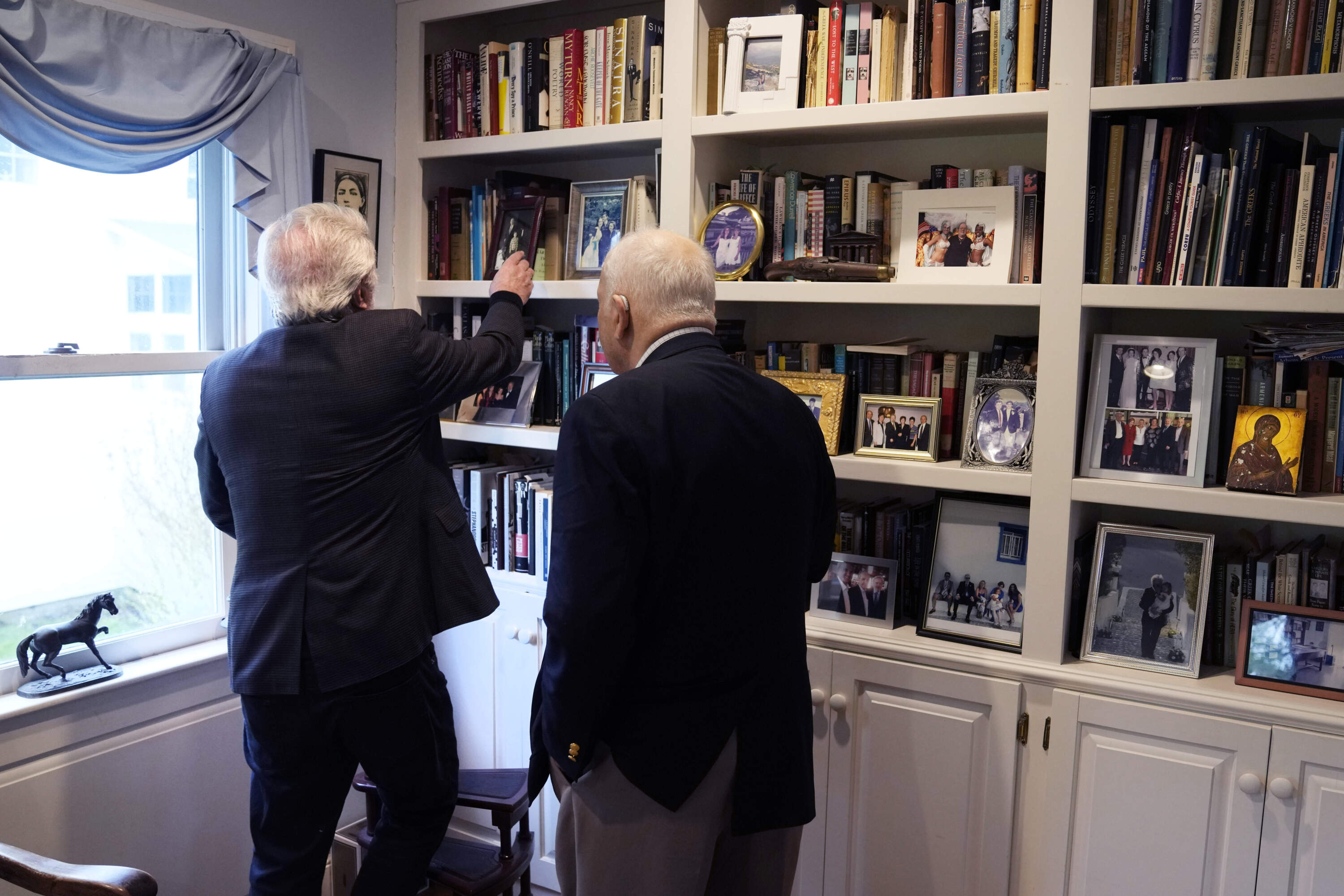 Nick Gage, left, selects a book from his library while talking with his longtime friend Nicholas Basbanes in Grafton, Mass. (Charles Krupa/AP)