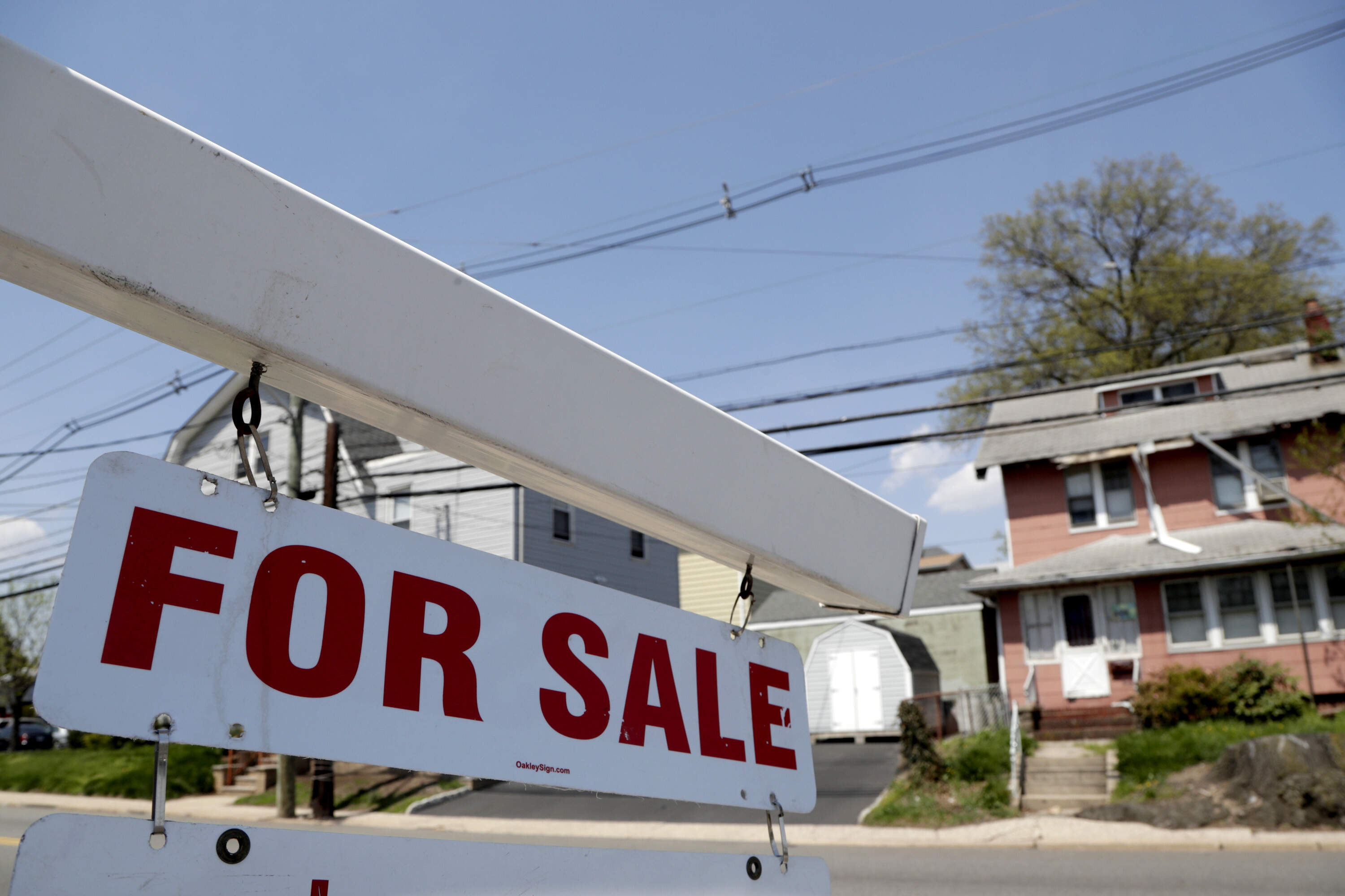 A for sale sign hangs from a post outside of a vacant building. (Julio Cortez/AP)