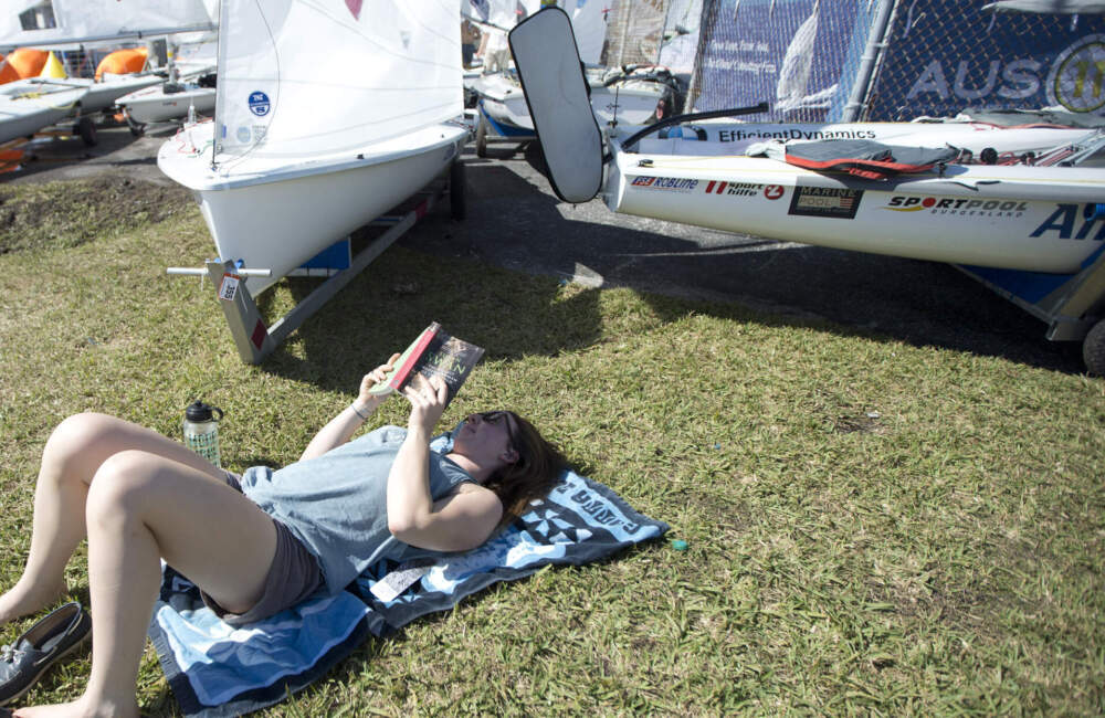 Rae-Anne Norwood, from Canada, lays in the sun reading a book. (J Pat Carter/AP)