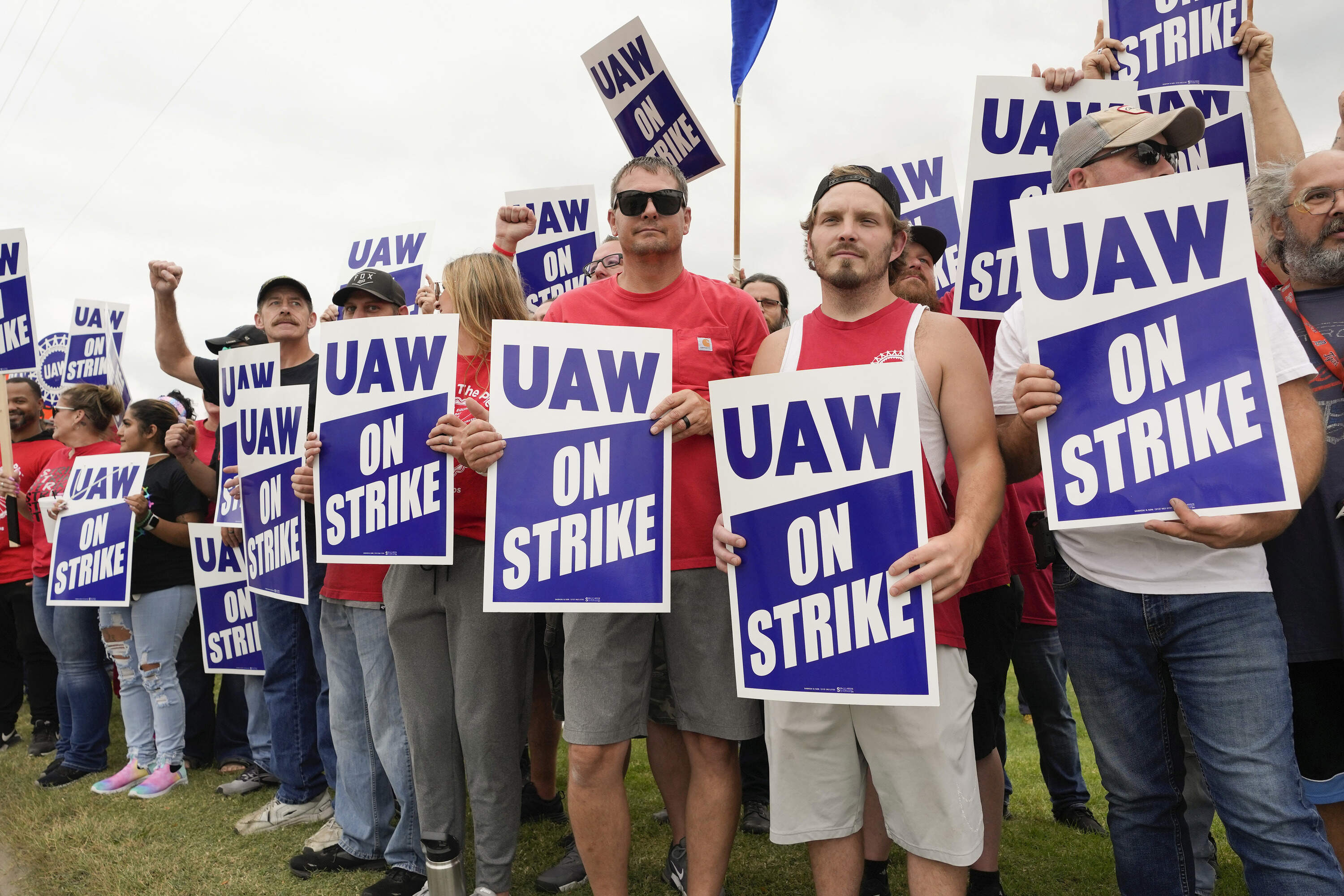 Striking United Auto Workers hold picket signs near a General Motors Assembly Plant in Delta Township, Mich., Friday, Sept. 29, 2023. (Paul Sancya/AP)