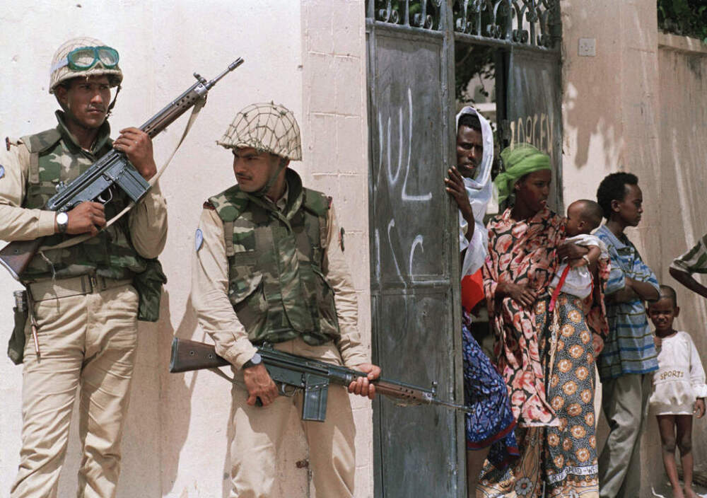 Somalis watch as Pakistani soldiers from the United Nations peacekeeping forces sweep through their neighborhood on June 9, 1993, in Mogadishu, in search of snipers responsible for the ambush of U.N. soldiers. (Kathy Willens/AP File)