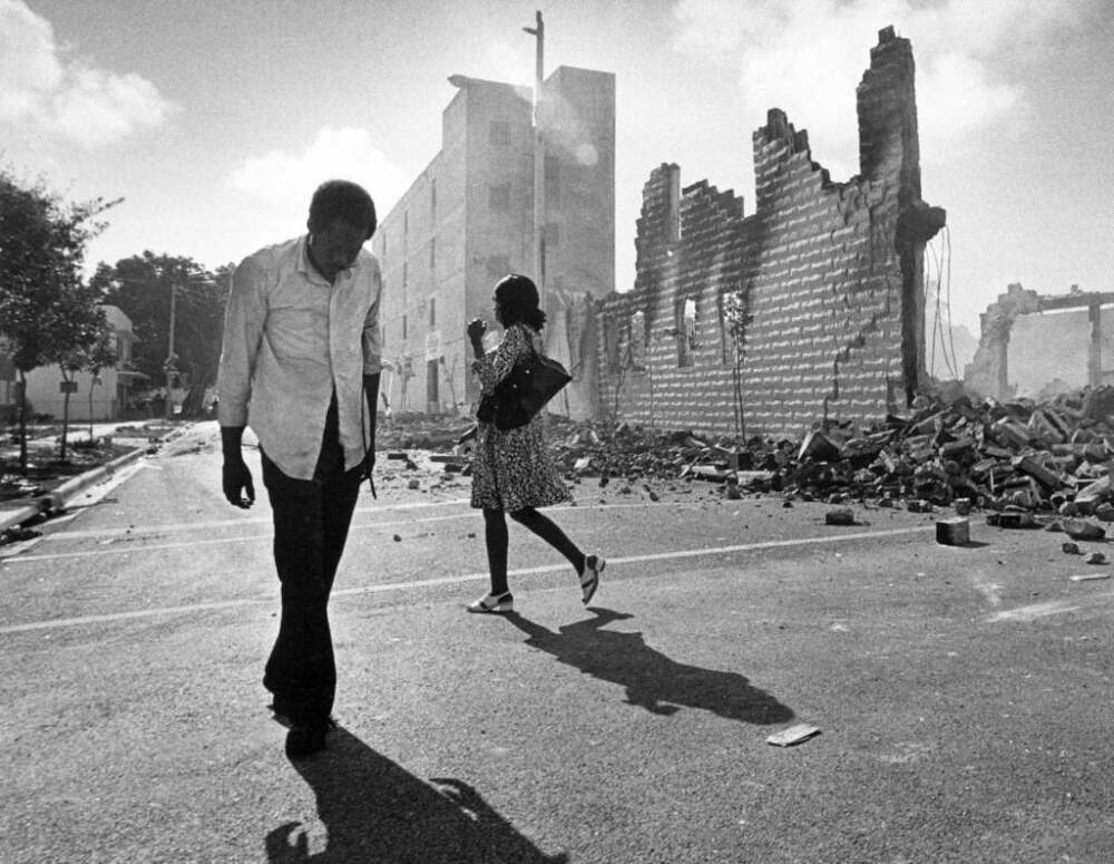People walk past ruins in the Culmer section of Miami on May 19, 1980, after rioting over the acquittal of four police officers charged with the 1979 beating death of Arthur McDuffie, a black motorcyclist. (Kathy Willens/AP File)