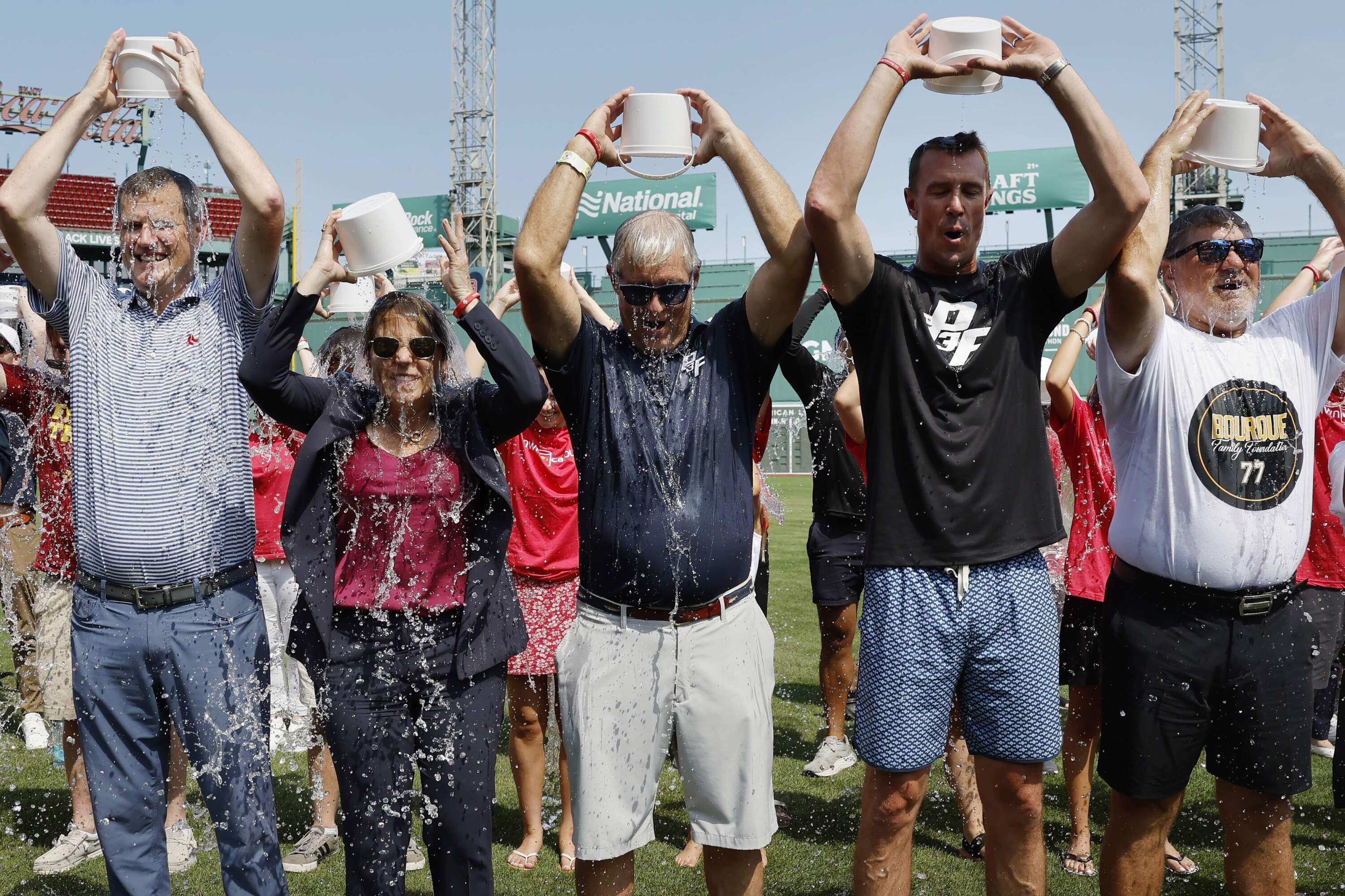 Boston Red Sox president and CEO Sam Kennedy, Massachusetts Gov. Maura Healey, John Frates, former Atlanta Falcons quarterback Matt Ryan and former Boston Bruins' Ray Borque pour water over their heads at Fenway Park, Thursday, Aug. 1, 2024. (Michael Dwyer/AP)