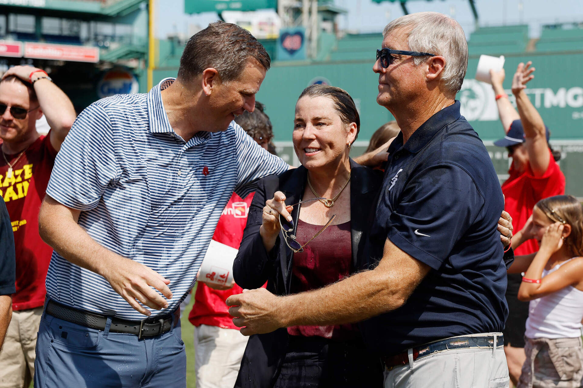 Boston Red Sox president and CEO Sam Kennedy, left, talks with Massachusetts Gov. Maura Healey, center, and John Frates, after taking the Ice Bucket Challenge during ceremonies on the fund raising event's 10th anniversary at Fenway Park, on Thursday, Aug. 1, 2024. (Michael Dwyer/AP)
