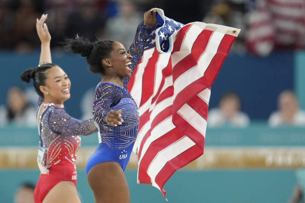 Simone Biles, of the United States, celebrates with teammate Suni Lee, left, after Biles won gold and Lee won bronze in the women's artistic gymnastics all-around finals in Bercy Arena at the 2024 Summer Olympics, Thursday, Aug. 1, 2024, in Paris, France. (AP Photo/Abbie Parr)