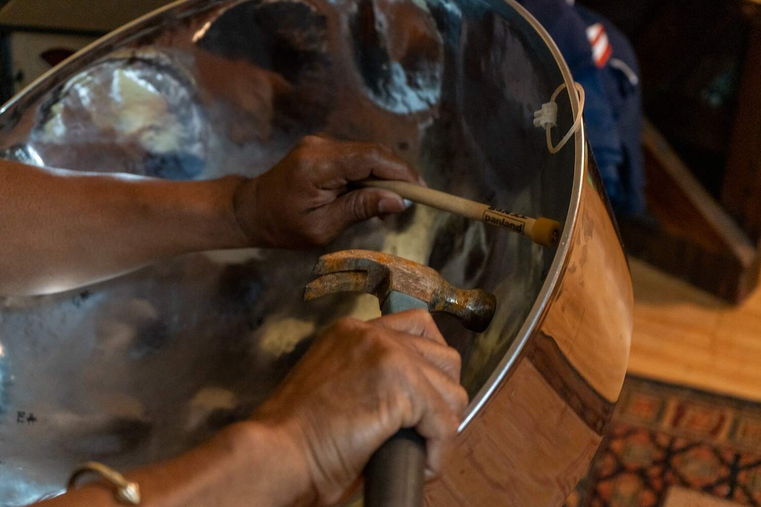 Ulric Johnson tuning the steel pan. (Sydney Ko/WBUR)