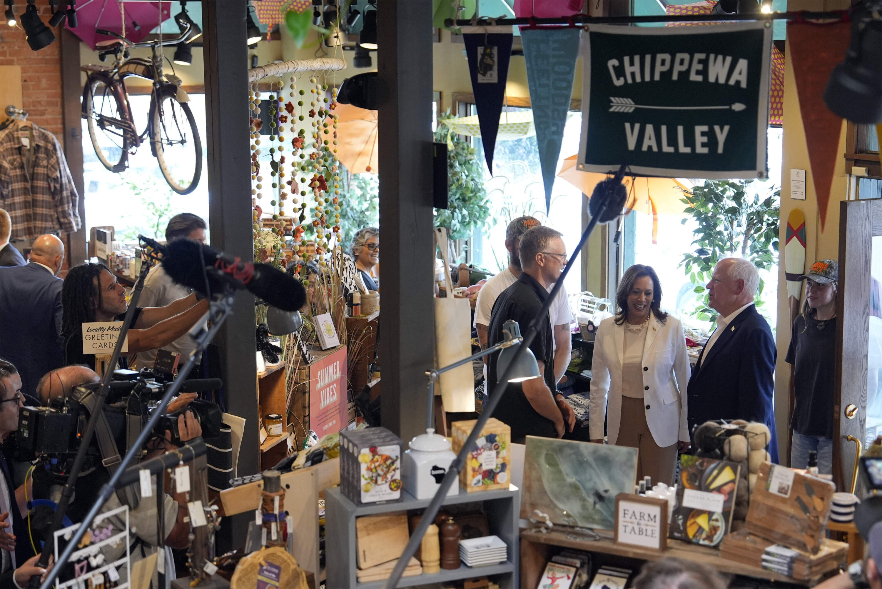 Democratic presidential nominee Vice President Kamala Harris and her running mate Minnesota Gov. Tim Walz talk with The Local Store and VoluneOne owner Nick Meyer Wednesday, Aug. 7, 2024, in Eau Claire, Wis. (AP Photo/Julia Nikhinson)
