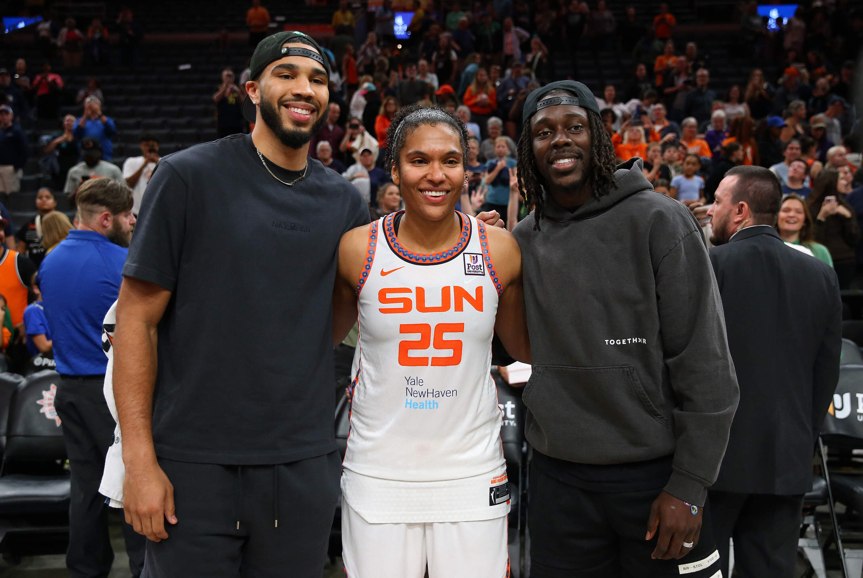 Boston Celtics forward Jason Tatum and guard Jrue Holiday pose for pictures with Connecticut Sun forward Alyssa Thomas (25) during the first WNBA game at TD Garden in Boston, MA. (M. Anthony Nesmith/Icon Sportswire via Getty Images)