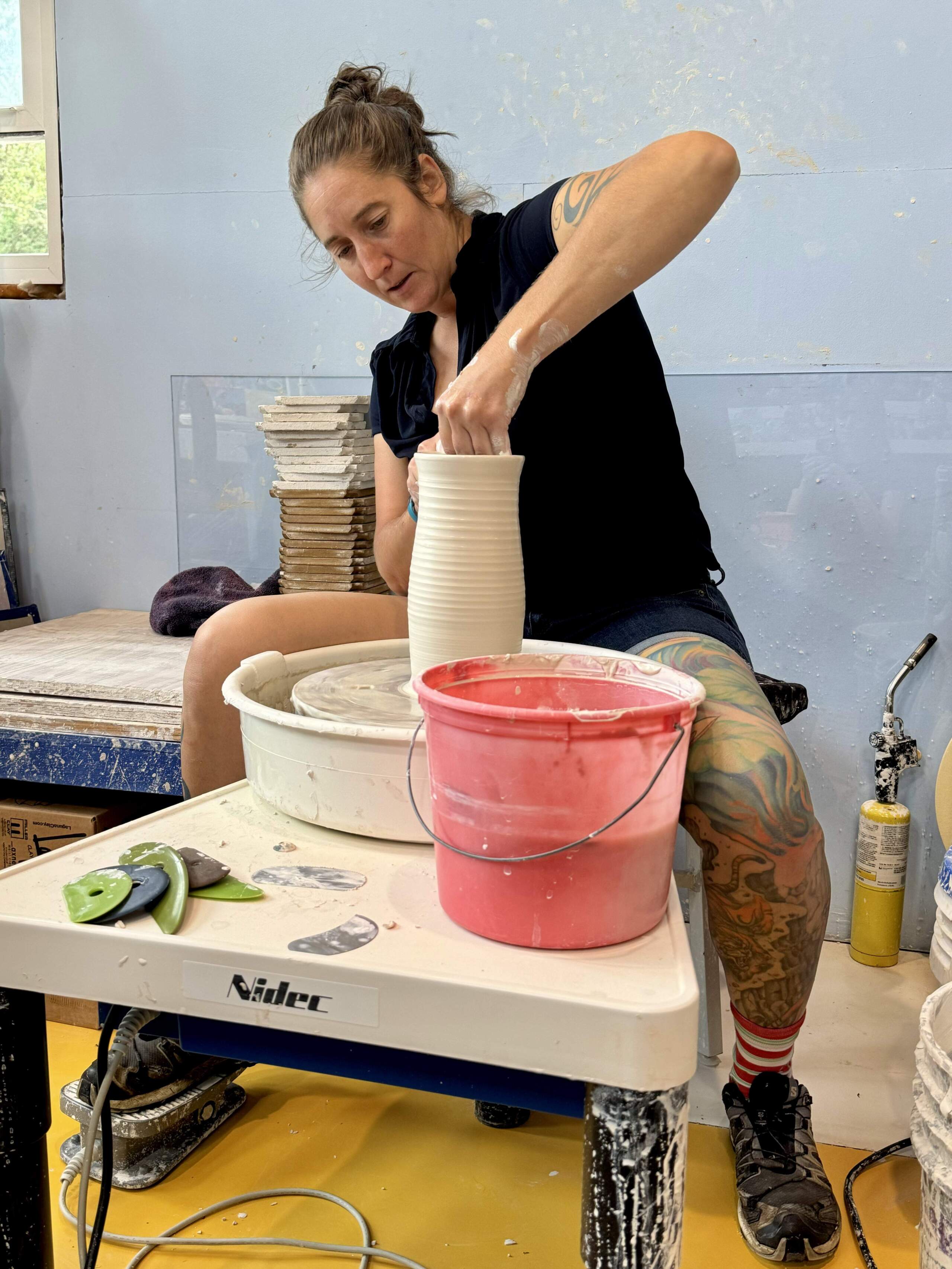 Lindsey Epstein demonstrating the early stages of a tulip vase on the pottery wheel. (Photo by Maddie Browning)
