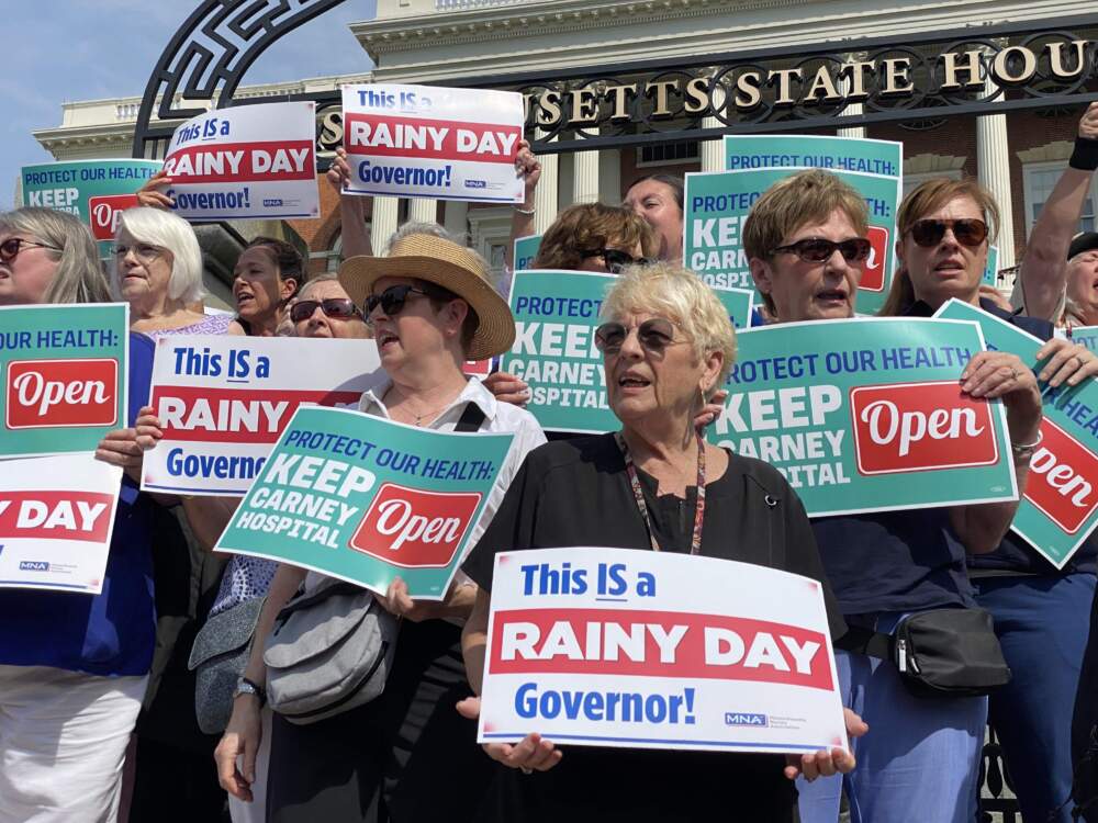 Advocates rally outside the State House Wednesday, a few days before Carney hospital is set to close. (Miriam Wasser/WBUR)