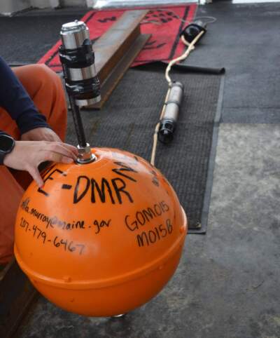 A team from the Department of Marine Resources prepares to deploy this passive acoustic monitor to a predetermined point in the Gulf of Maine. (Courtesy of Jeff Nichols, Maine Department of Marine Resources via Maine Public)